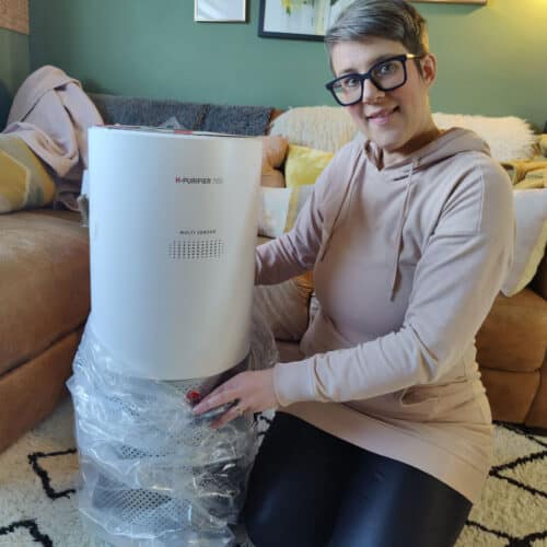 A middle aged white woman unpacks an air purifier in her living room