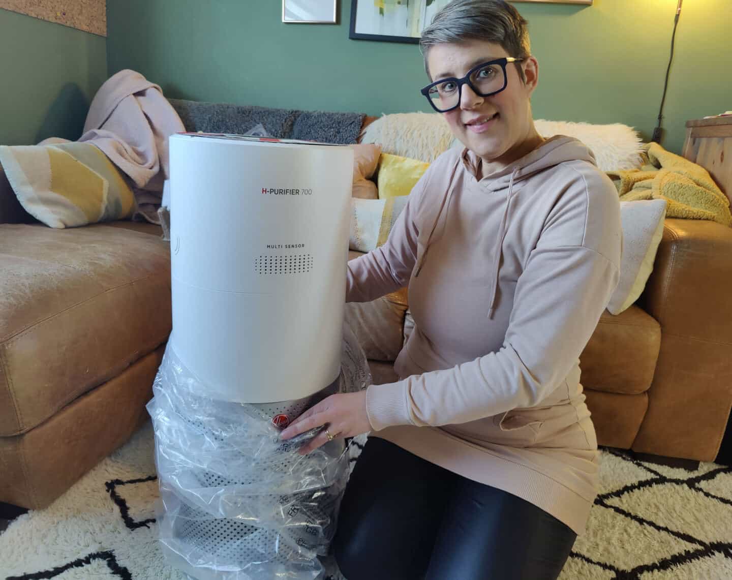 A middle aged white woman unpacks an air purifier in her living room