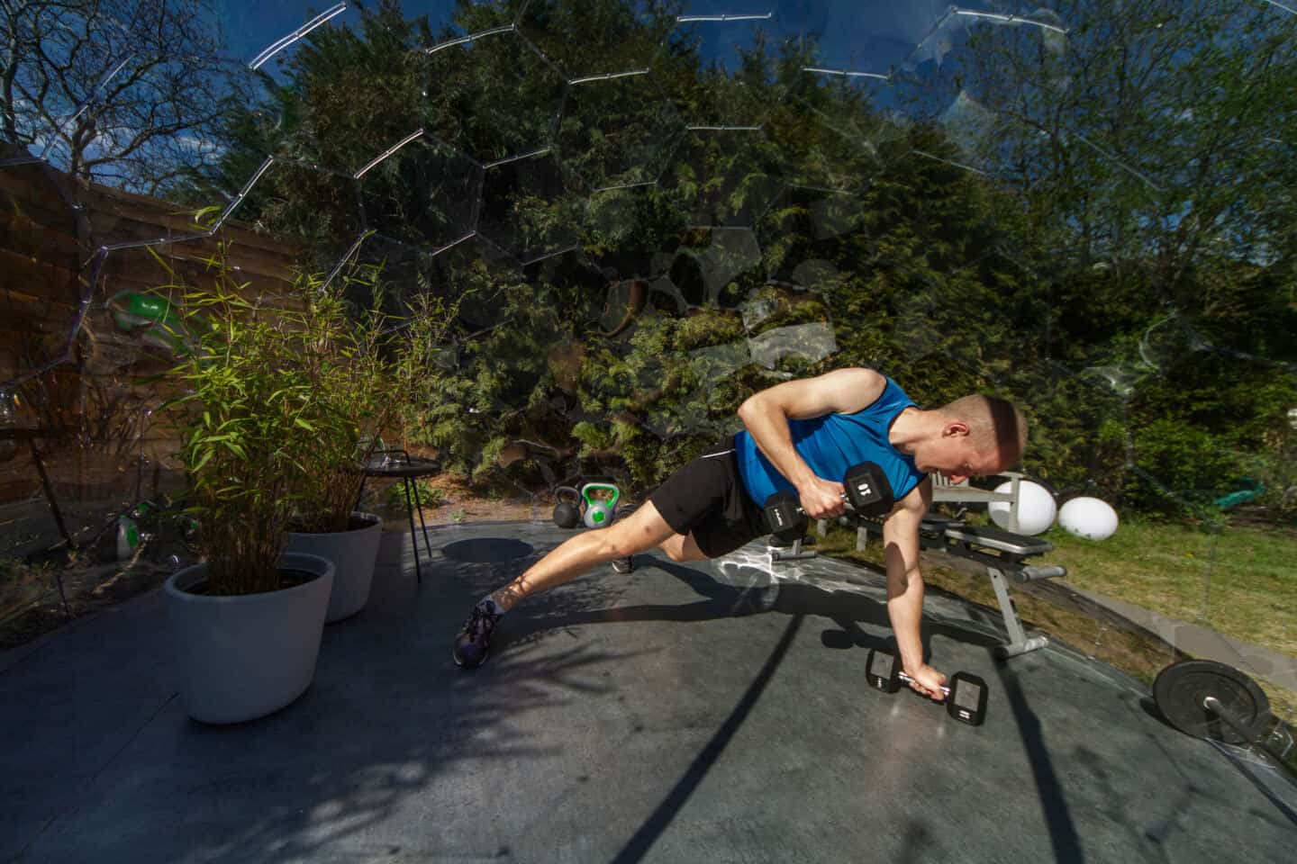 A man doing weight training inside a garden dome