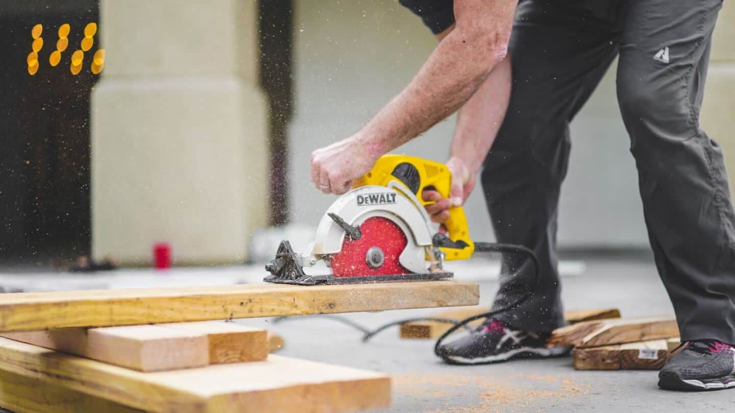 A man using a circular saw to chop wood for a home renovation project