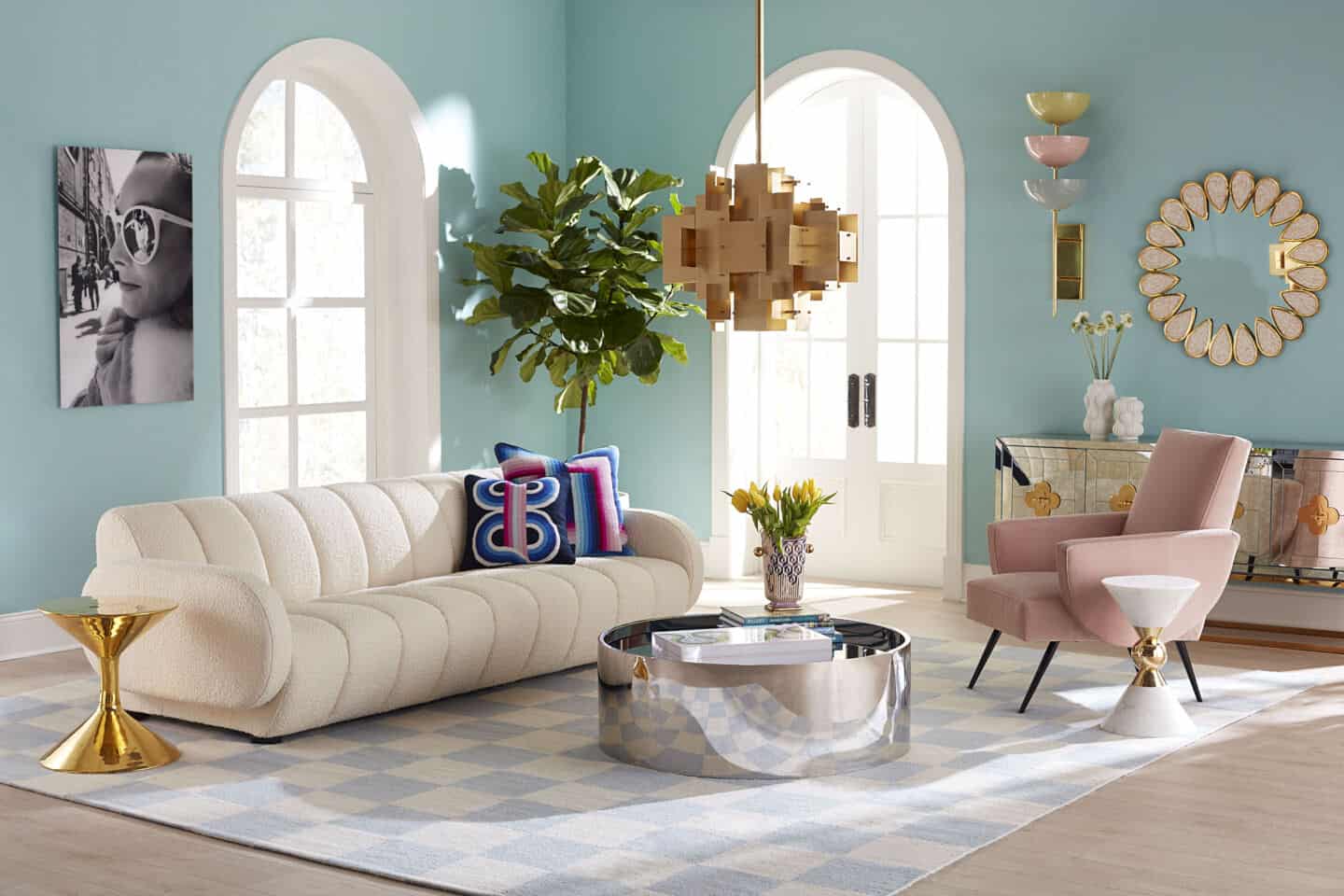 Jonathan Adler's Brigitte sofa in bouclé texiles in a living room setting. The livingroom is in pastel hues and the sofa is on a chequered rug