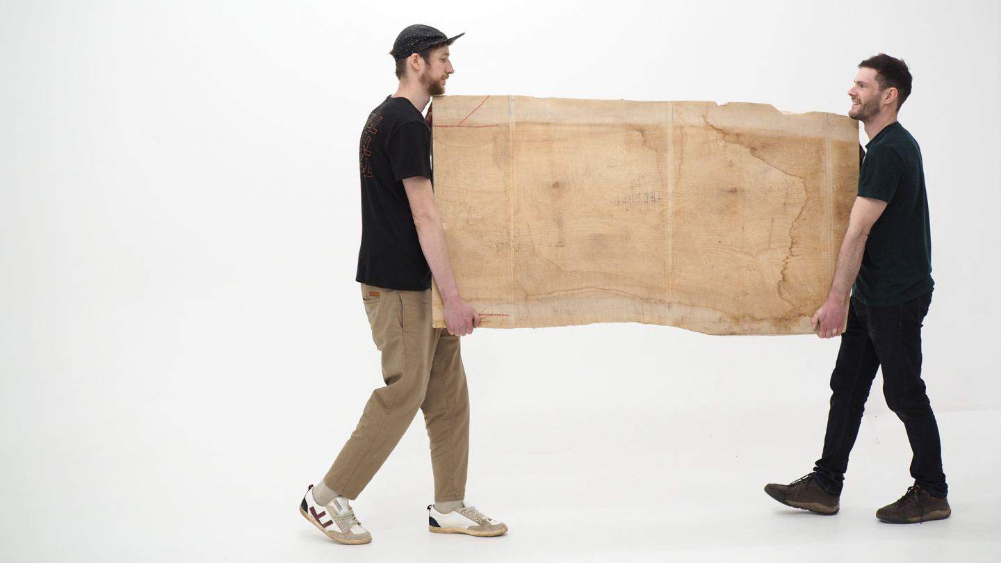 Oli and Josh of Forge Creative carrying a large piece of wood