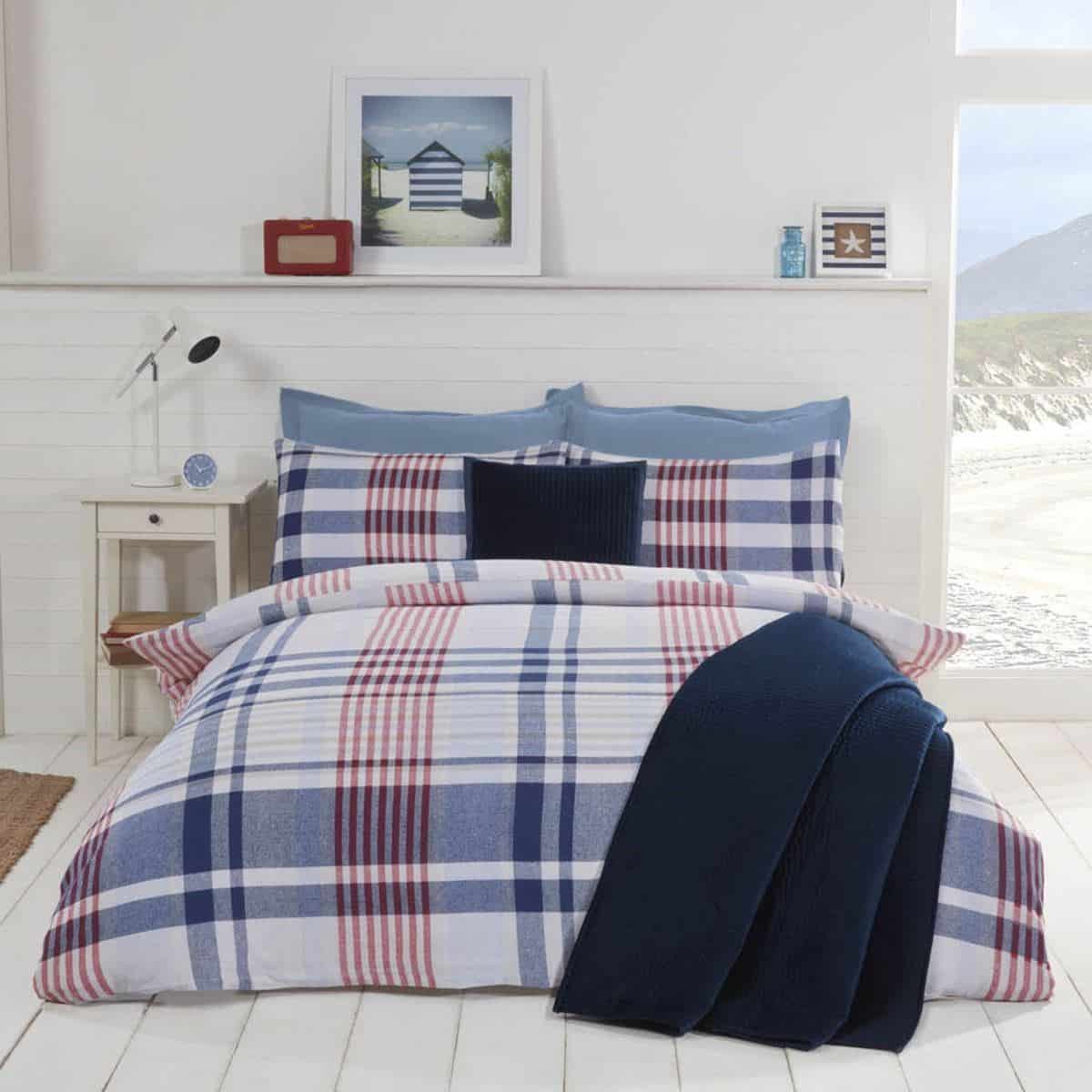 A blue and white nautical themed bedroom featuring checked bedding. Blue is a very calming colour and great for helping to achieve good quality sleep.