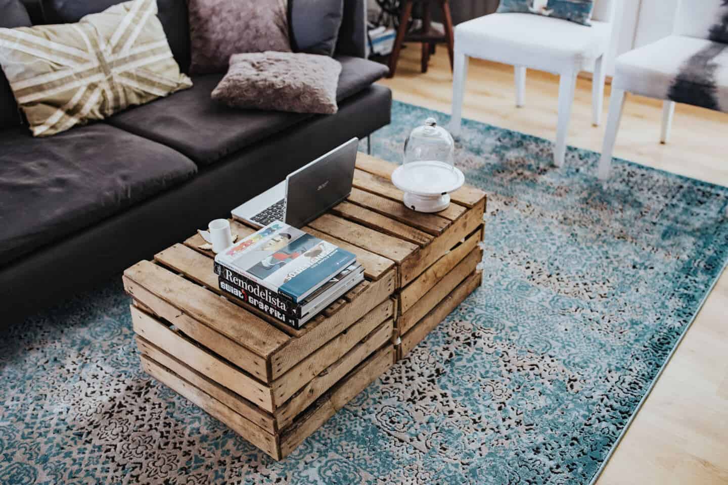 A large blue rug covers wooden flooring in a living room