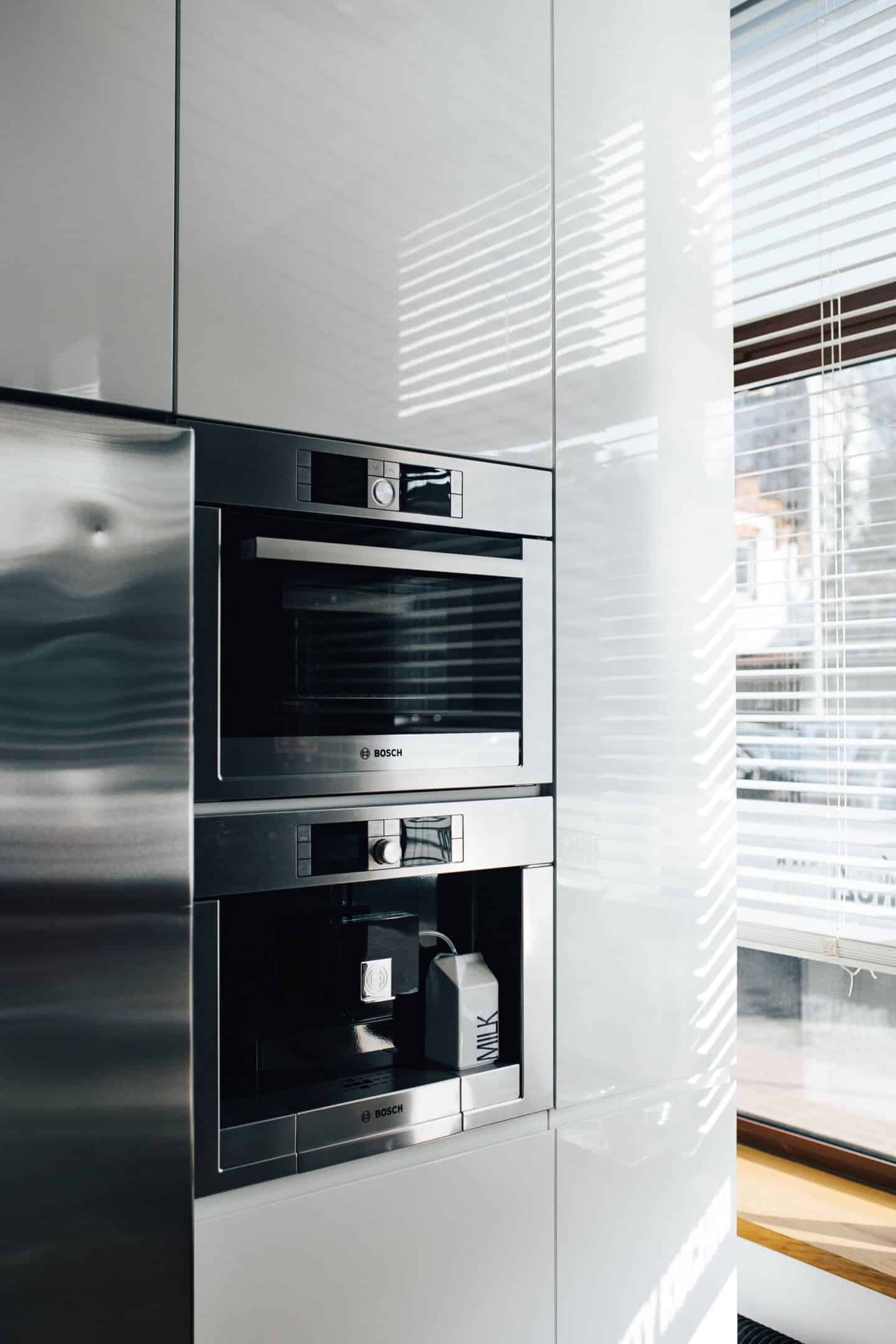 Close up of a built-in oven and coffee machine