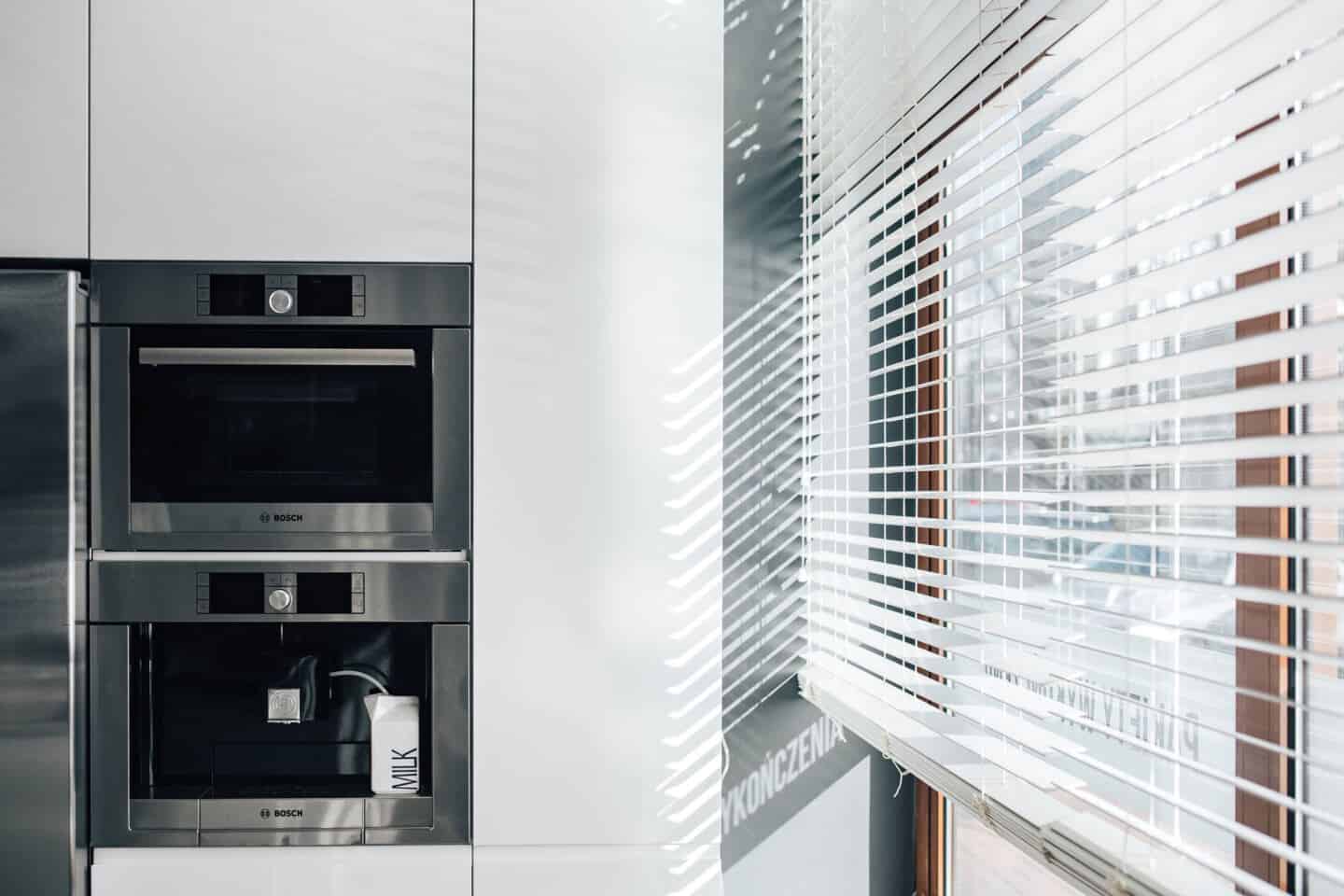 Close up of a built-in oven and coffee machine