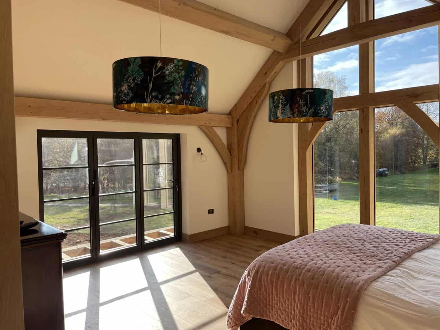 Aluminium bifold doors create beautiful shadows on the floor of this timber framed bedroom