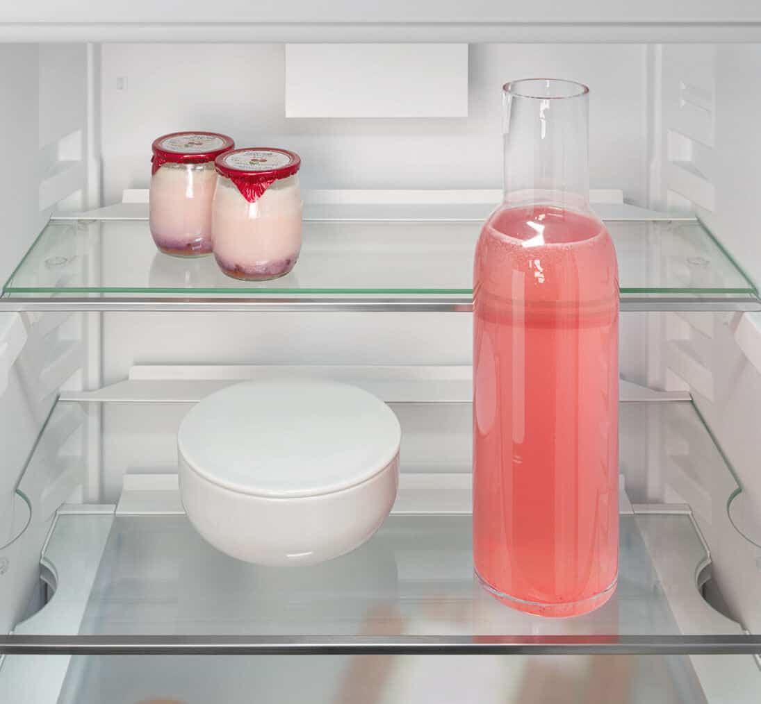 Liebherr's fully integrated appliance range. A glass shelf is divided in two to make space in the fridge for a tall bottle.