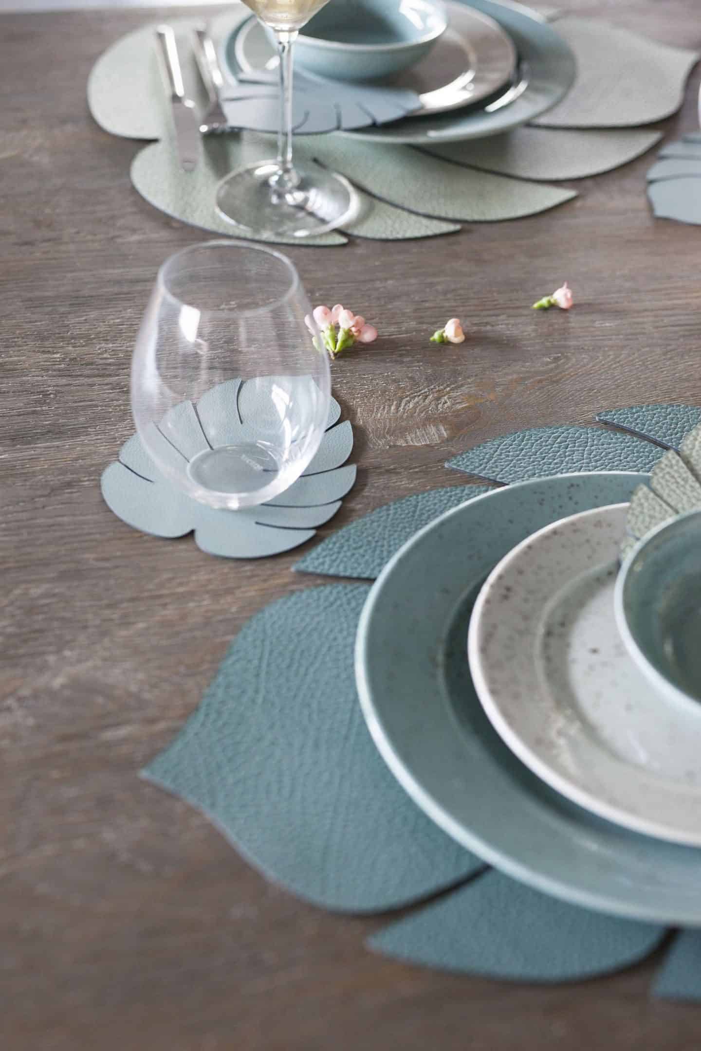 Green recycled leather placemats in th eshape of monstera leaves by LIND DNA