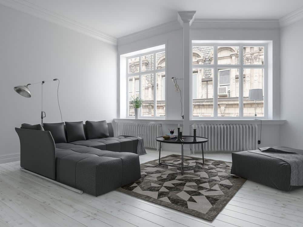 Radiator buying guide featuring column radiators below the windows in a monochrome living room