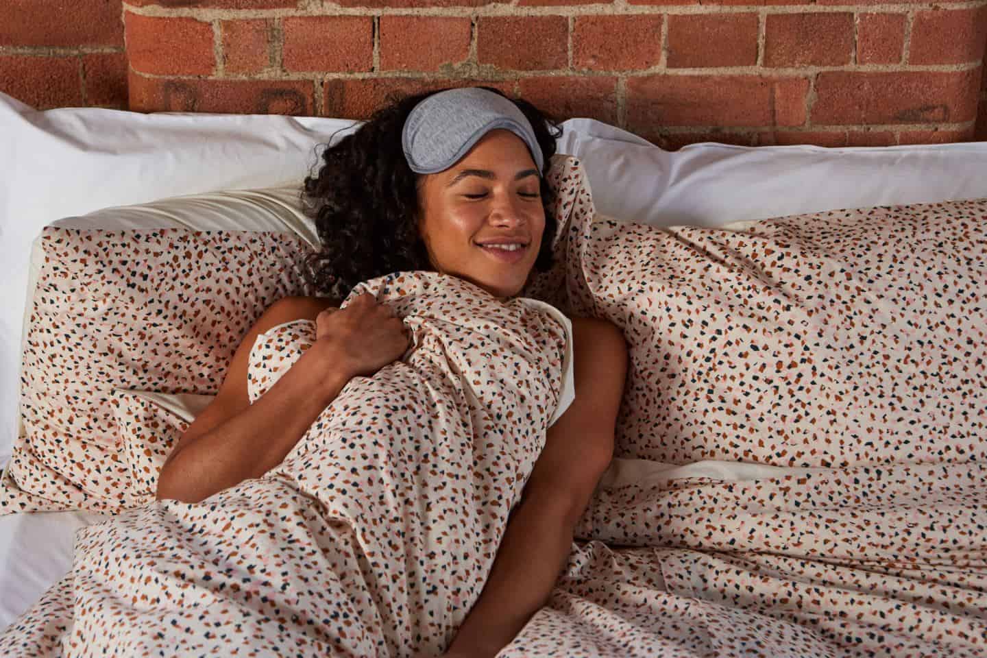 Koa revolutionary duvet cover. A woman in bed in an industrial loft bedroom. The easy way to change a duvet cover