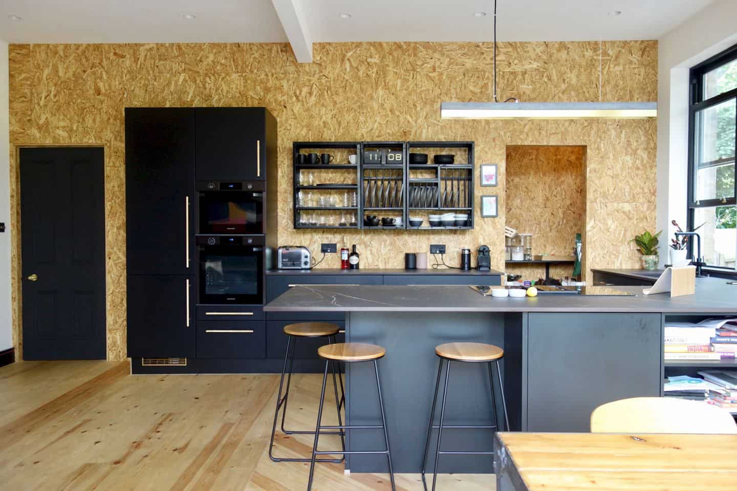 Kitchen design trends - black kitchen by Making Spaces using osb board on the walls