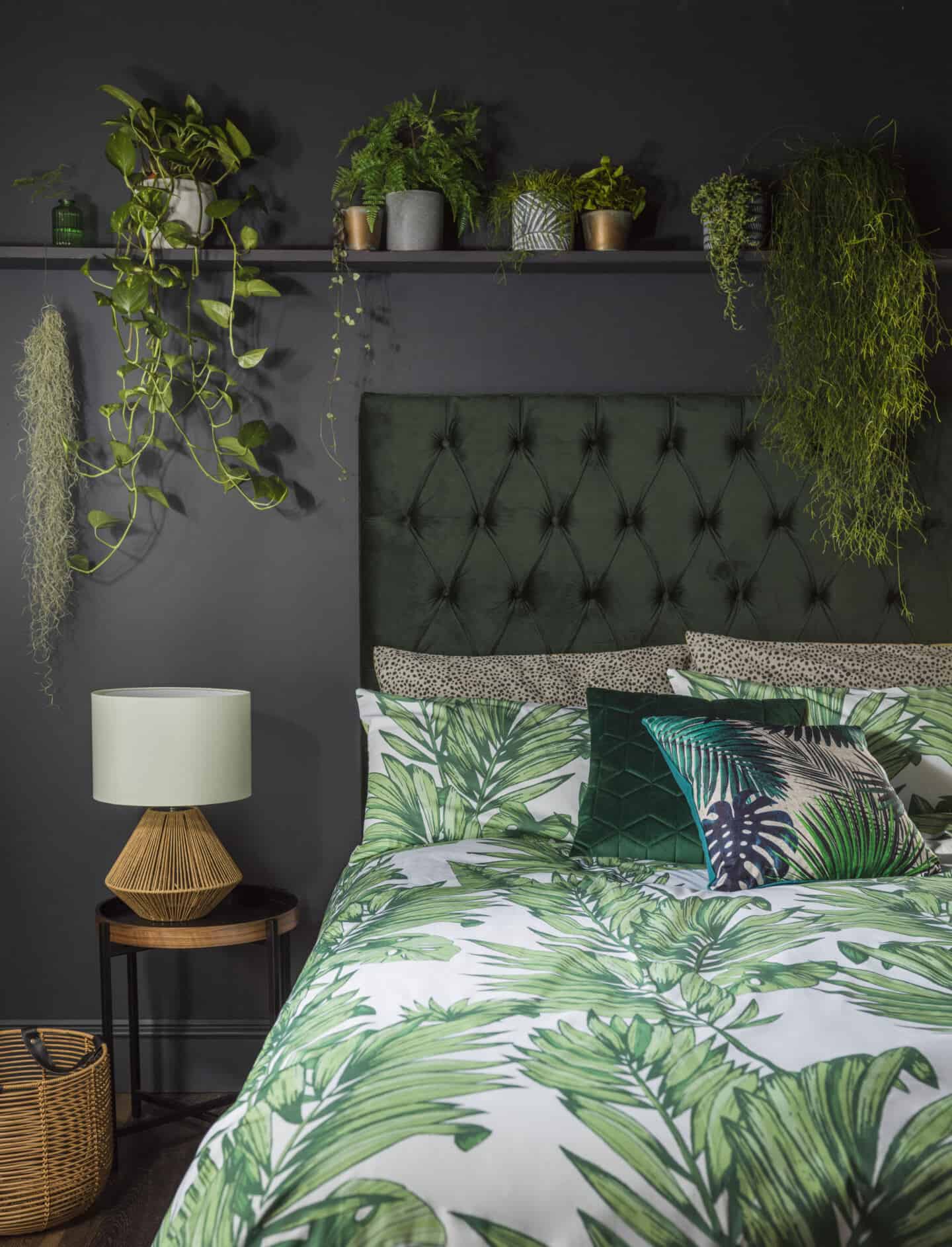 Botanist is a SS20 interiors trend by Very.co.uk that features nature in interiors. This bedroom features a plush velvet headboard, printed leafy bedding and lots of plants on a shelf above the bed