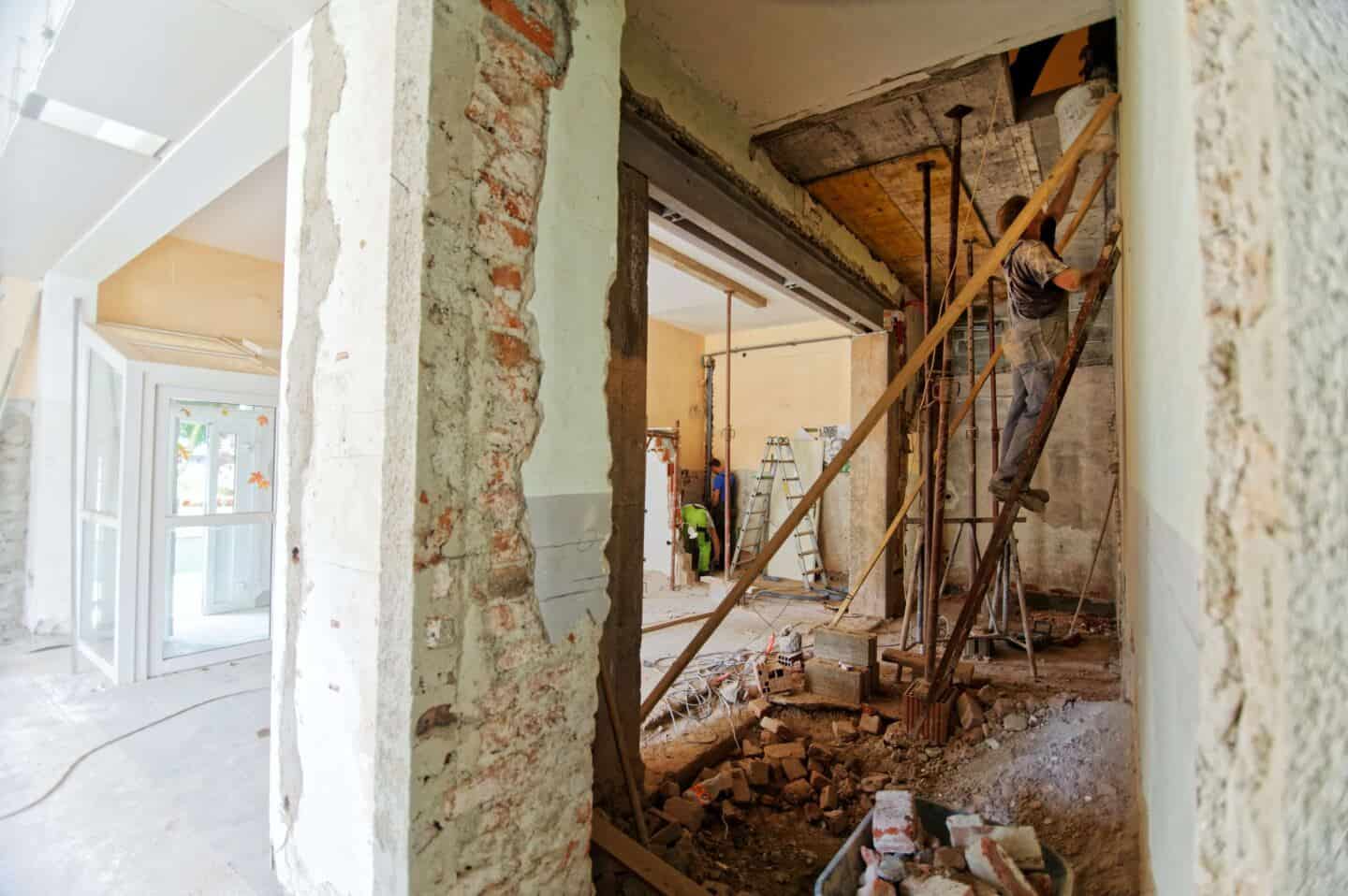 A man up a ladder doing work on a home renovation project