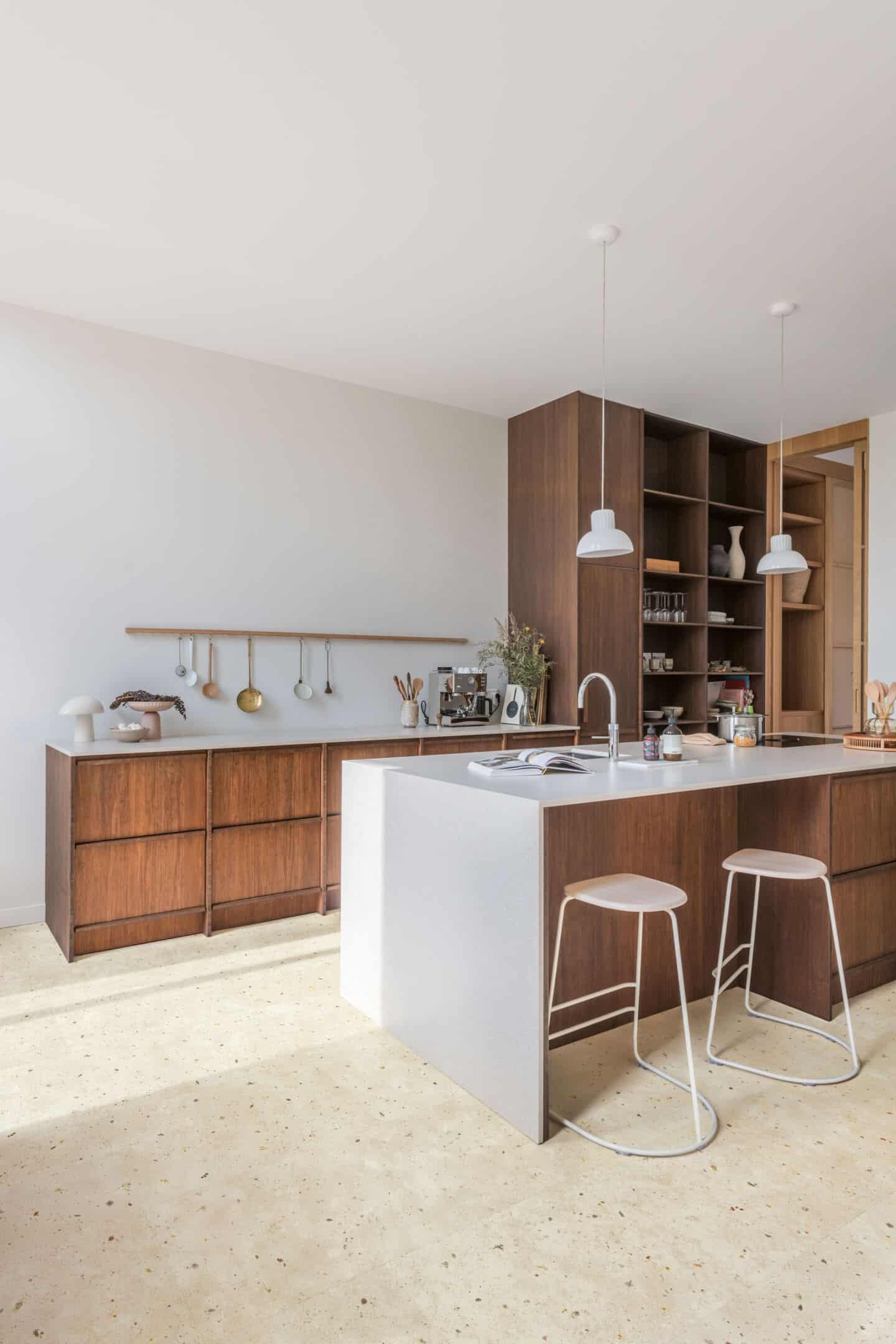 A minimalist wooden kitchen with a nature-inspired laminate flooring. Flooring is Botanic Concrete from Quickstep