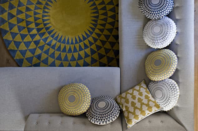 Grey sofa topped with a selection of geometric cushions by Niki Jones