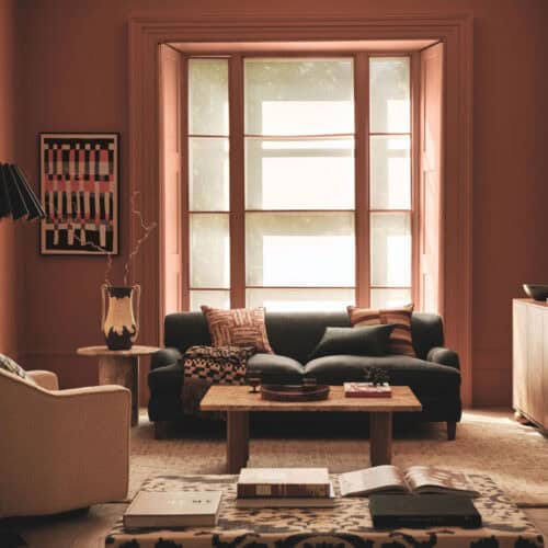 A living room in earthy colour palette with large windows to promote home health