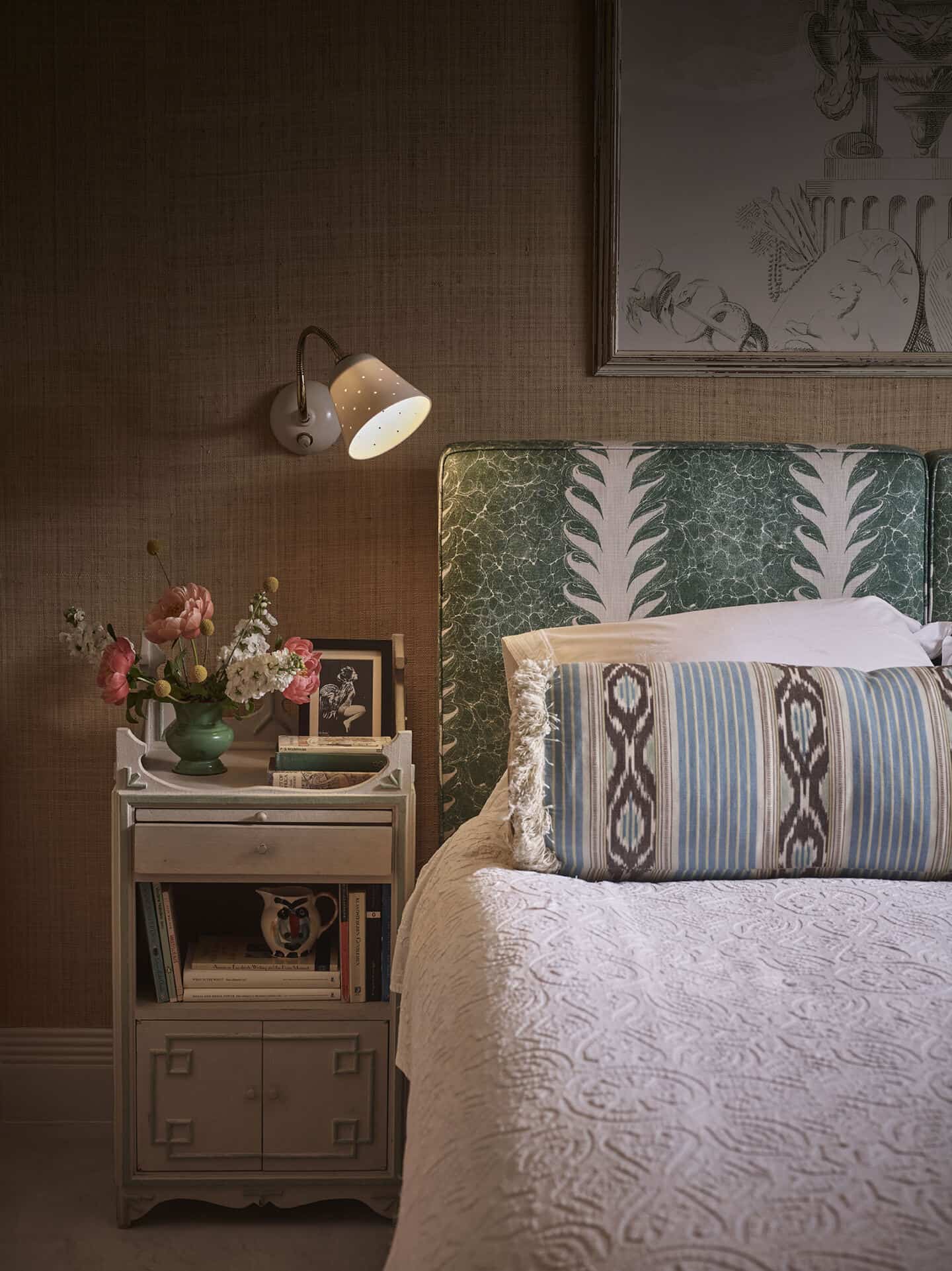 a bed next to a bedside table with a wall light above from Original BTC