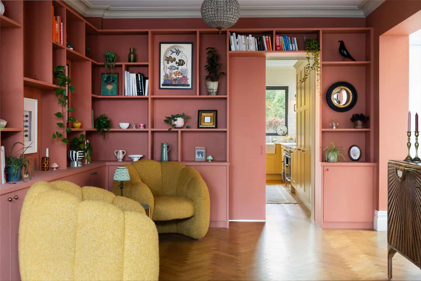 A peach living room with floor-to-ceiling, wall-to-wall shelving