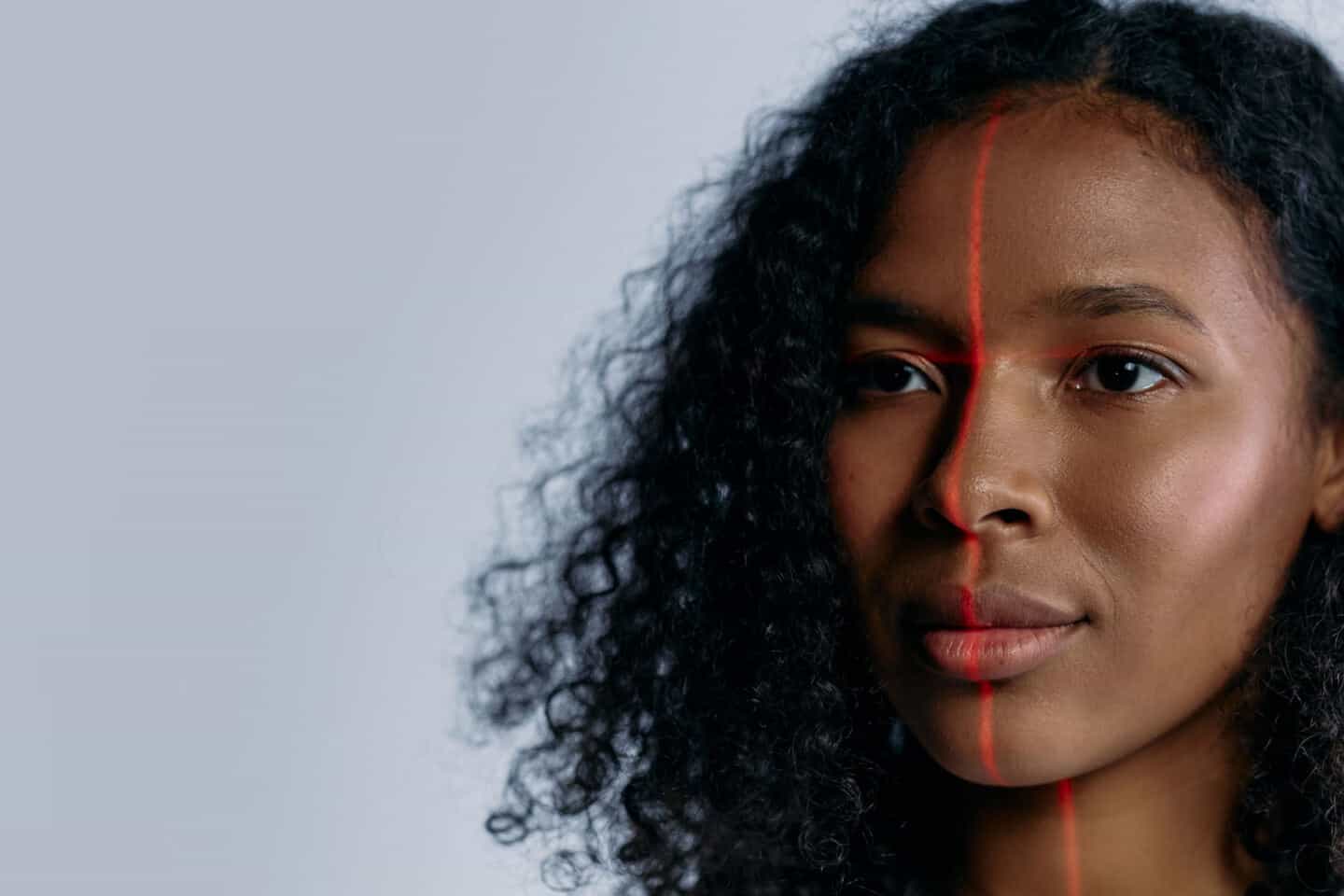 A black woman in her 30s with a red laser on her face