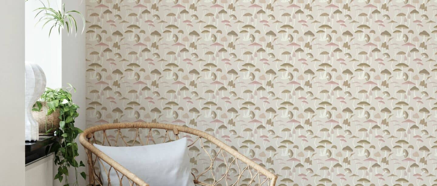 A rattan chair positioned next to a window with mushroom wallpaper behind