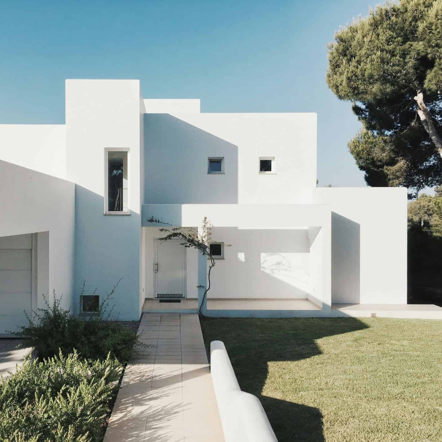 Modern white minimal villa with green lawn