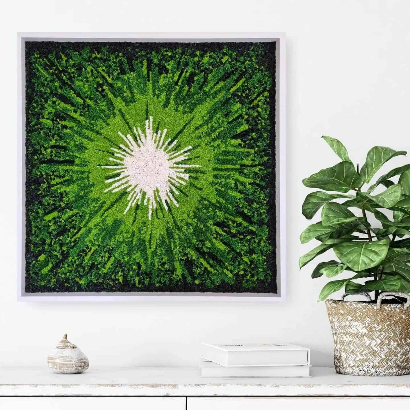 Framed moss wall art by Ninfa Studio hangs on the wall above a side board next to a house plant