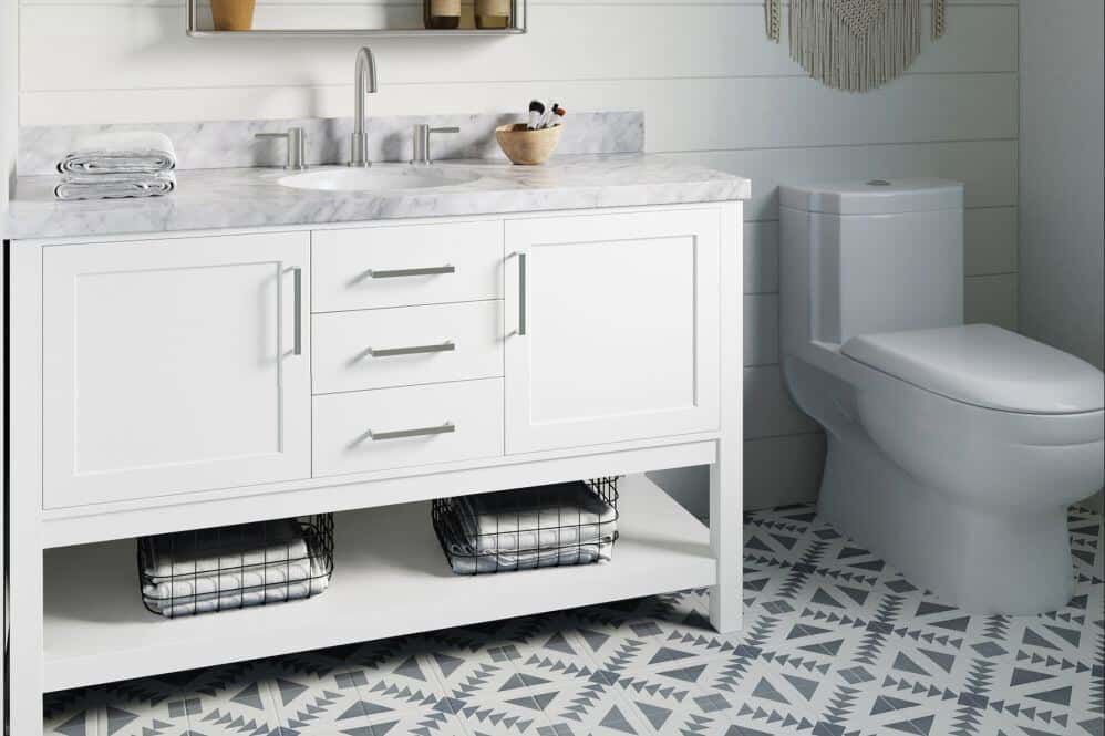 Arielbath white vanity with marble effect counter beside toilet. Black and white patterned tile floor