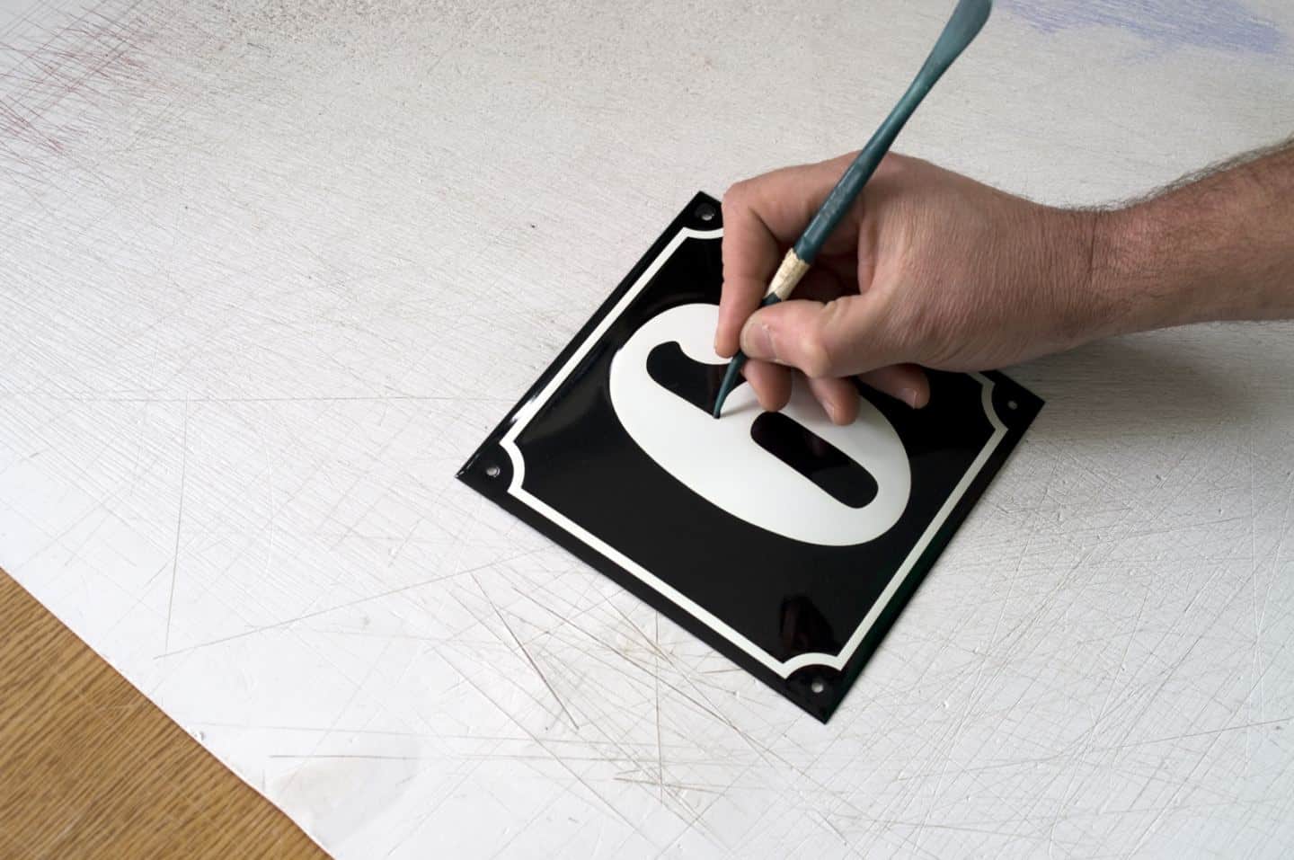 Hand-painting enamel signs for homes and businesses at Ramsign