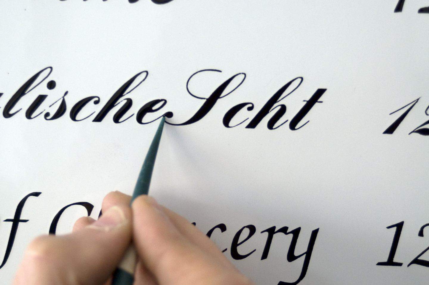 Hand-painting enamel signs for homes and businesses