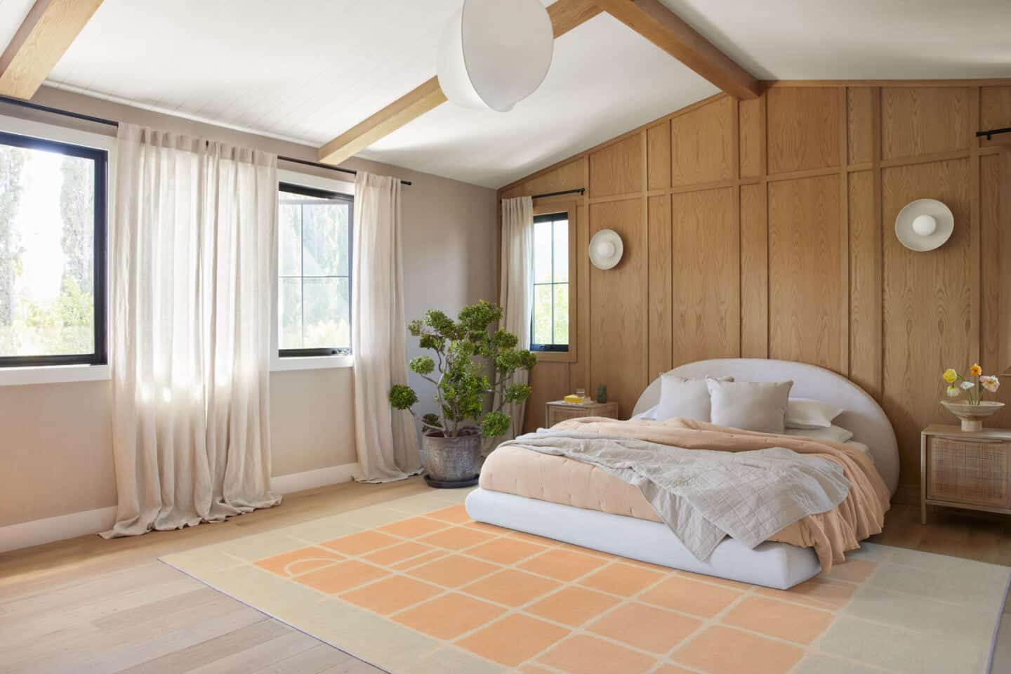 A bedroom featuring a large floor rug from Ruggable in Pantone Colour of the Year 2024 Peach Fuzz