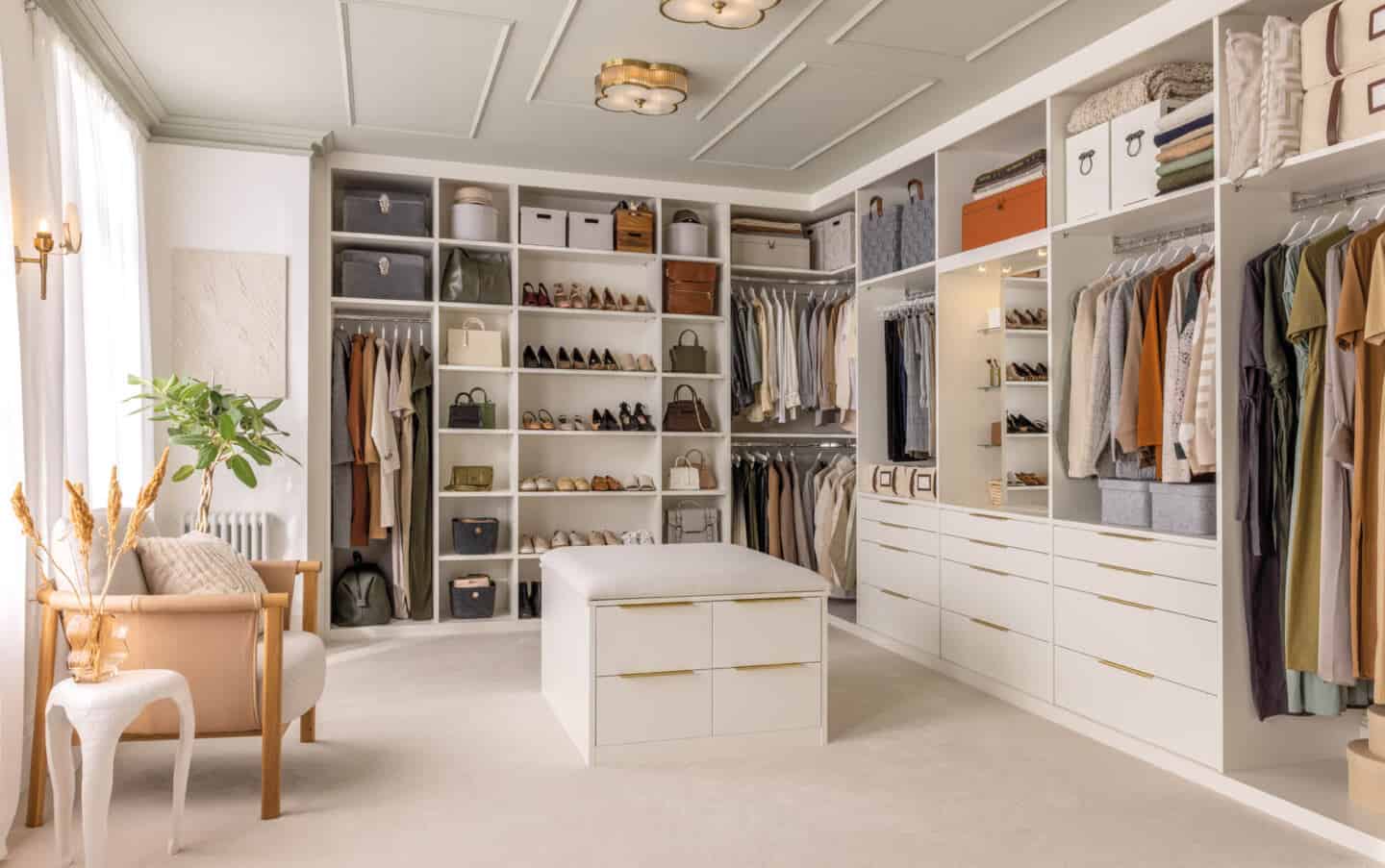 walk-in-wardrobe with walls lined with cupboards and a central island.