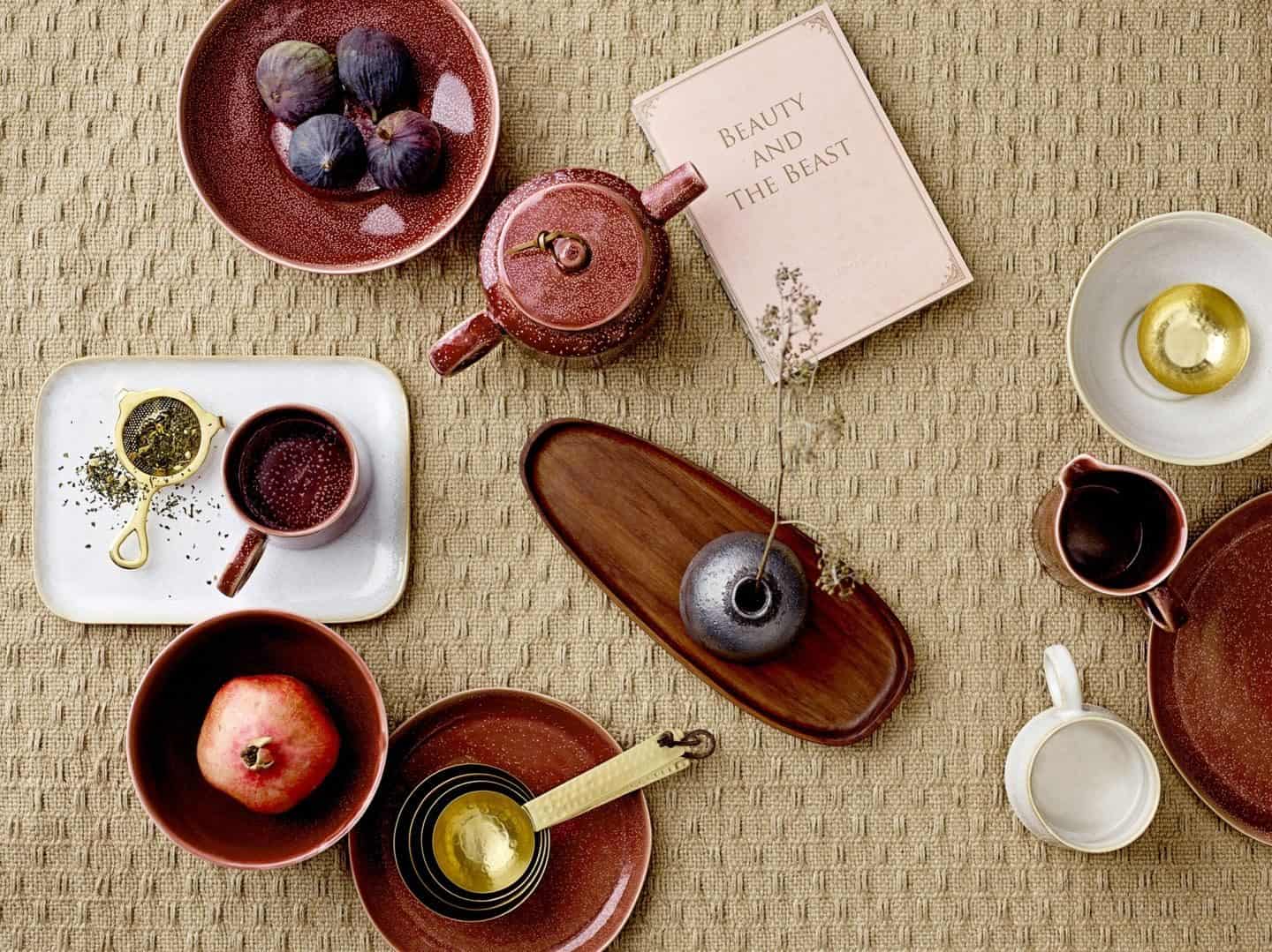 Shekåbba The Danish Home is an online retailer that stocks a range of Danish homewares. Flatlay of rustic ceramics on a textured tablecloth