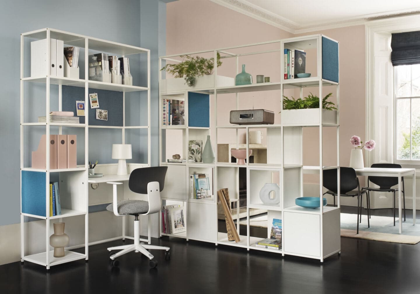 An open plan living-dining room featuring a modular desk unit made from storage shelving