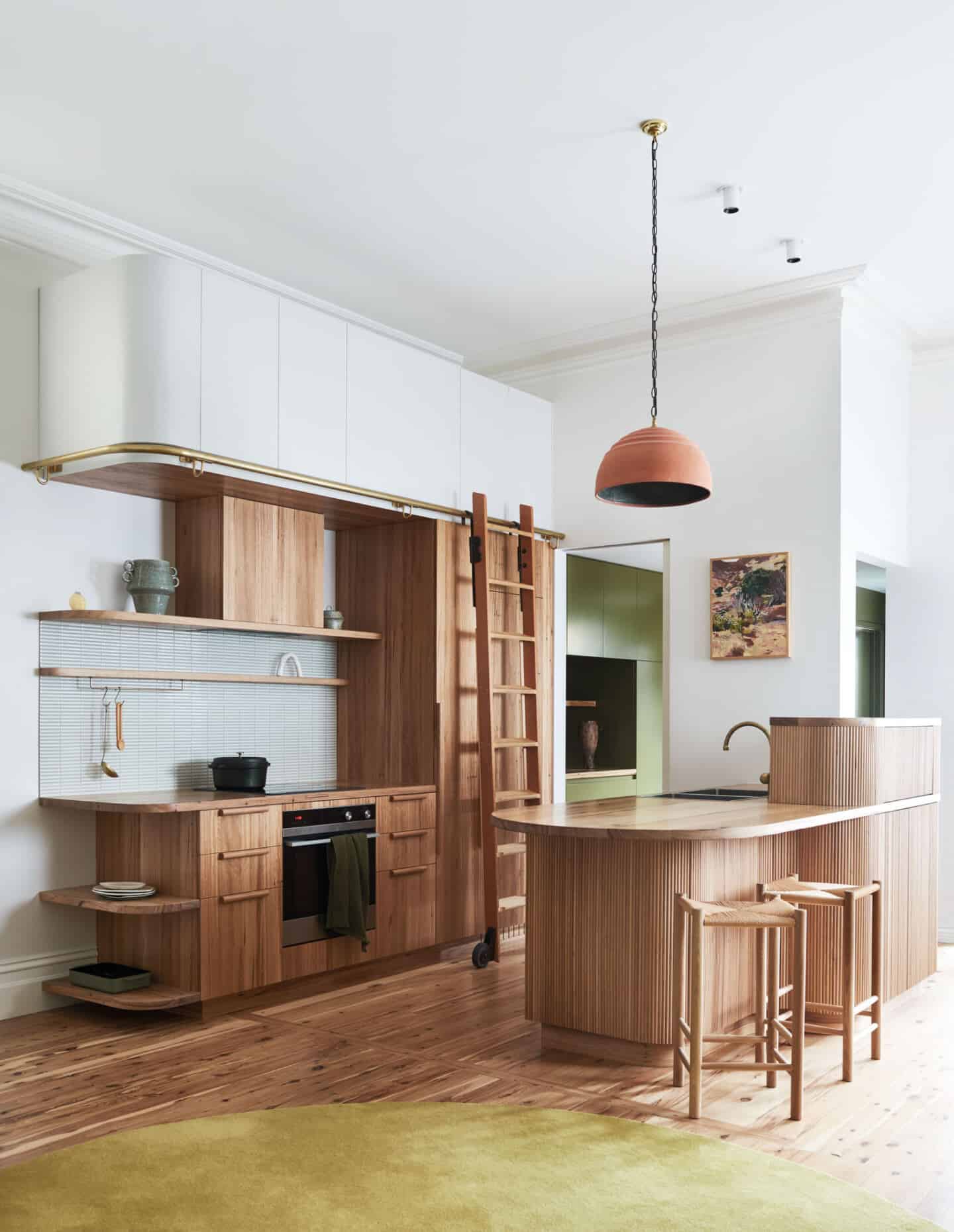 A modern wood kitchen with curved edges and fluted surfaces.