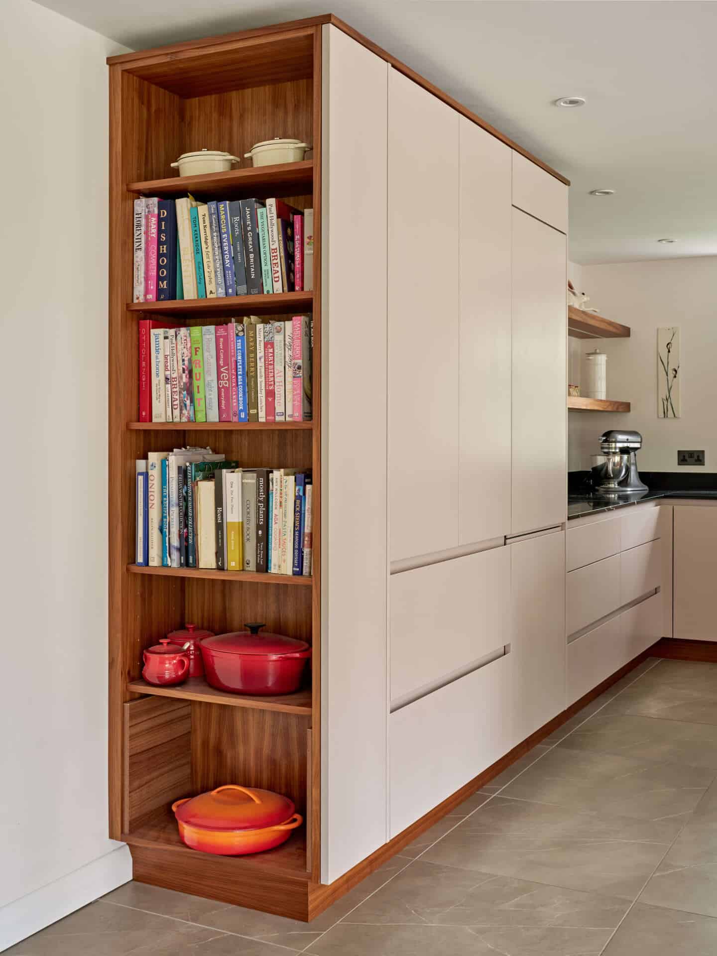 A modern handless kitchen in cream with additional shelf storage on the kitchen end panel