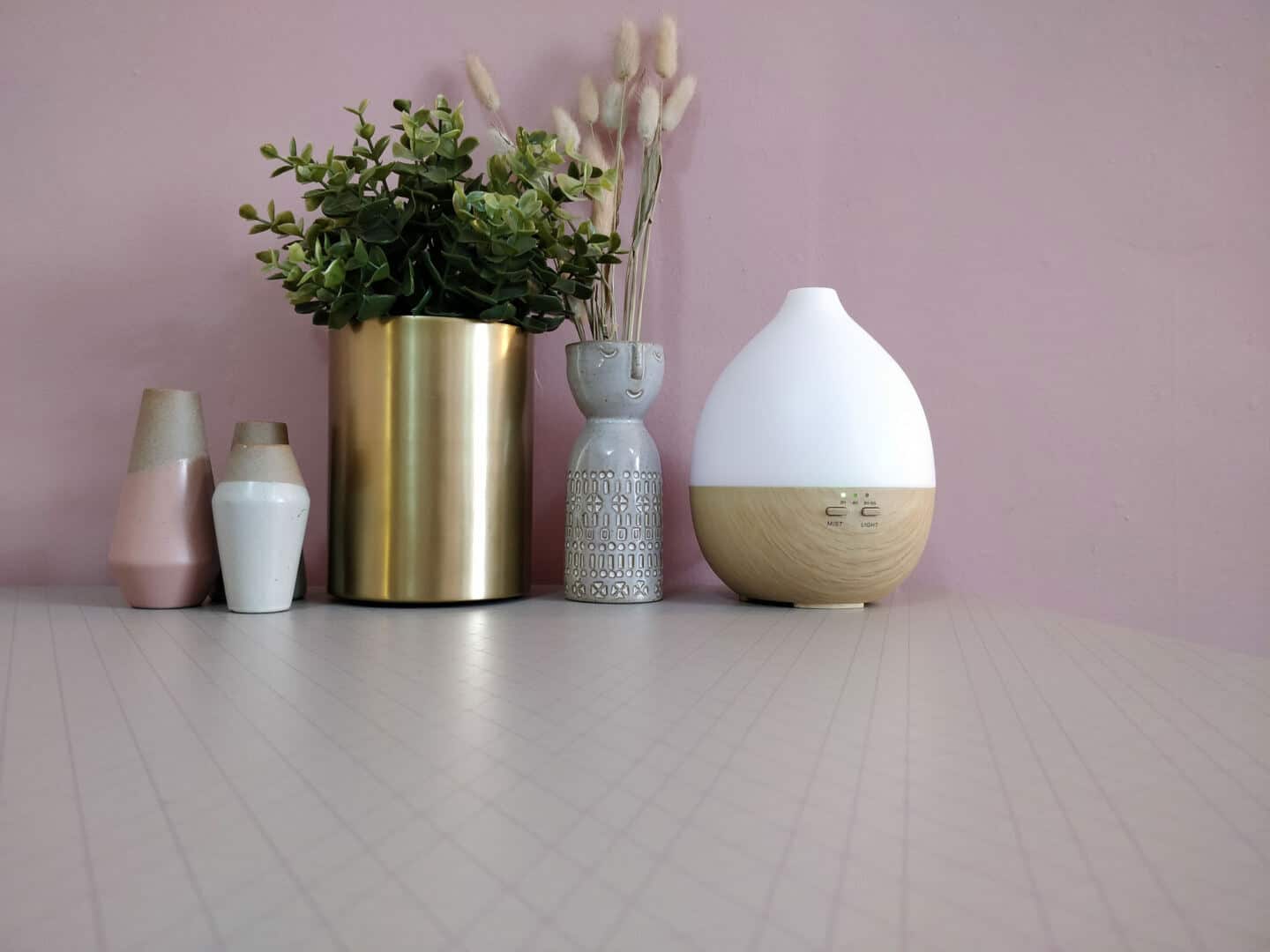 Smellacloud aroma diffuser on a table with plants and vases