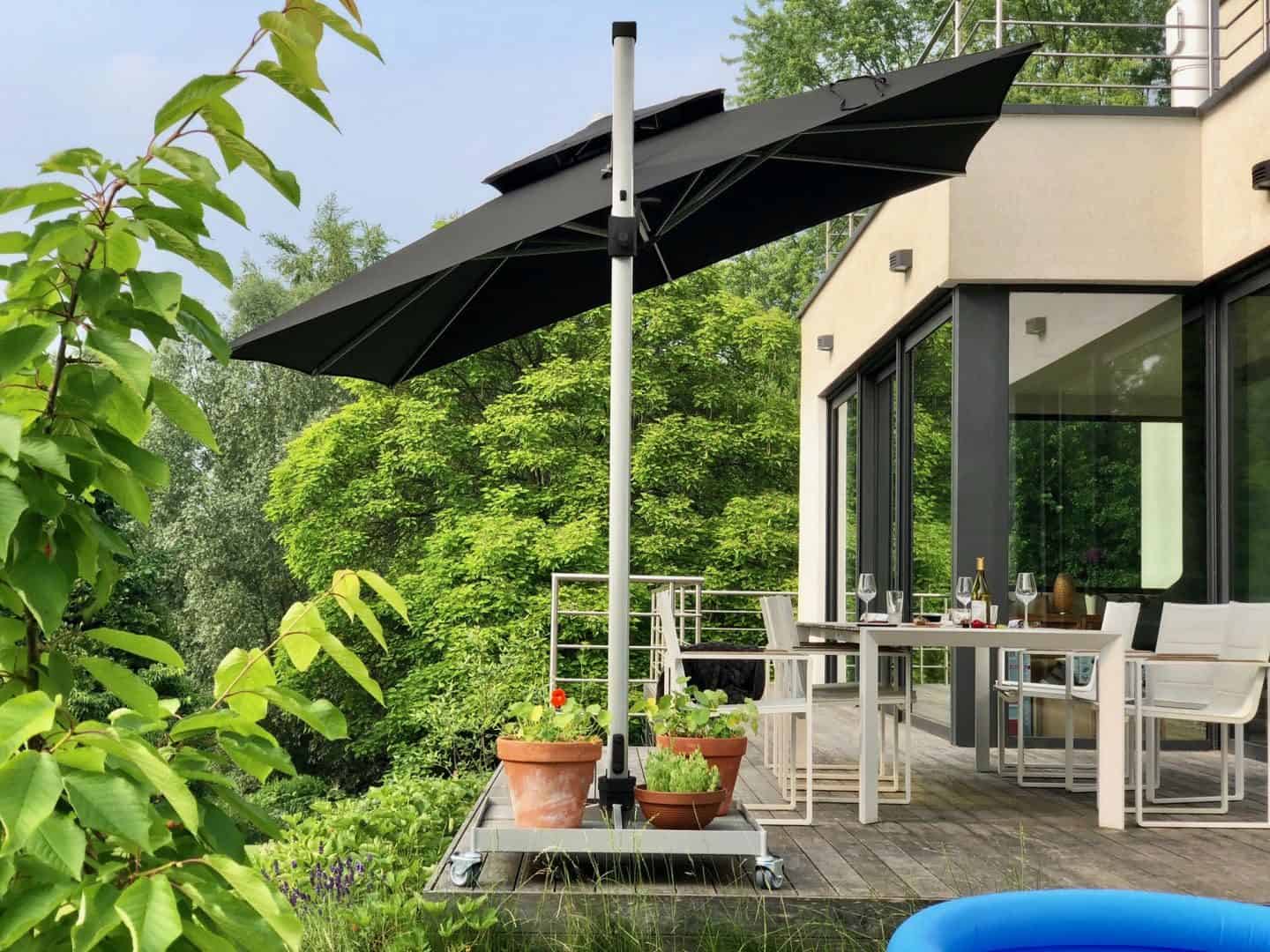 Garden Parasol from Solero Parasols. Large square garden parasol on a wheeled base. The parasol is angled over the garden furniture.