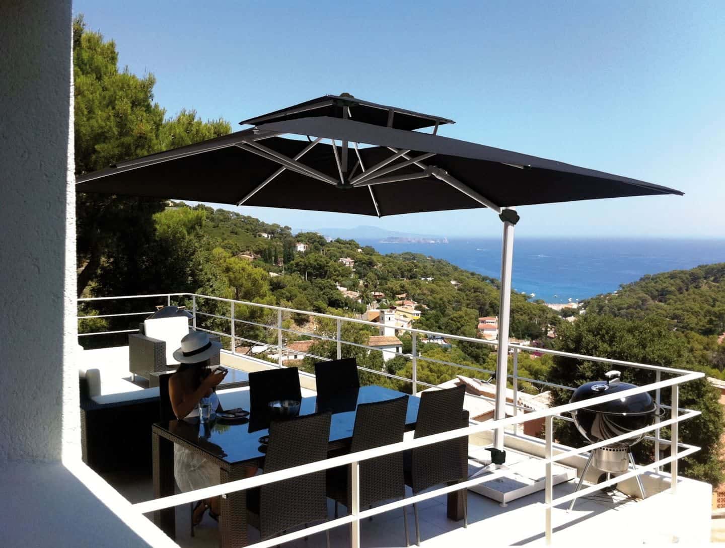 Garden Parasol from Solero Parasols.  Large black square cantilevered parasol providing shade over a garden dining set. 