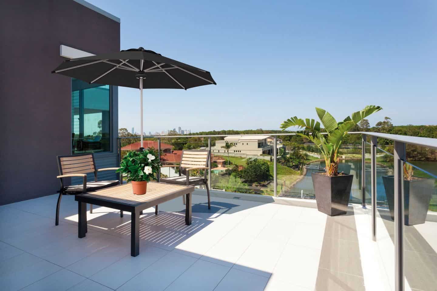 Garden Parasol from Solero Parasols.  Large black garden parasol above an outdoor furniture set on a terrace.