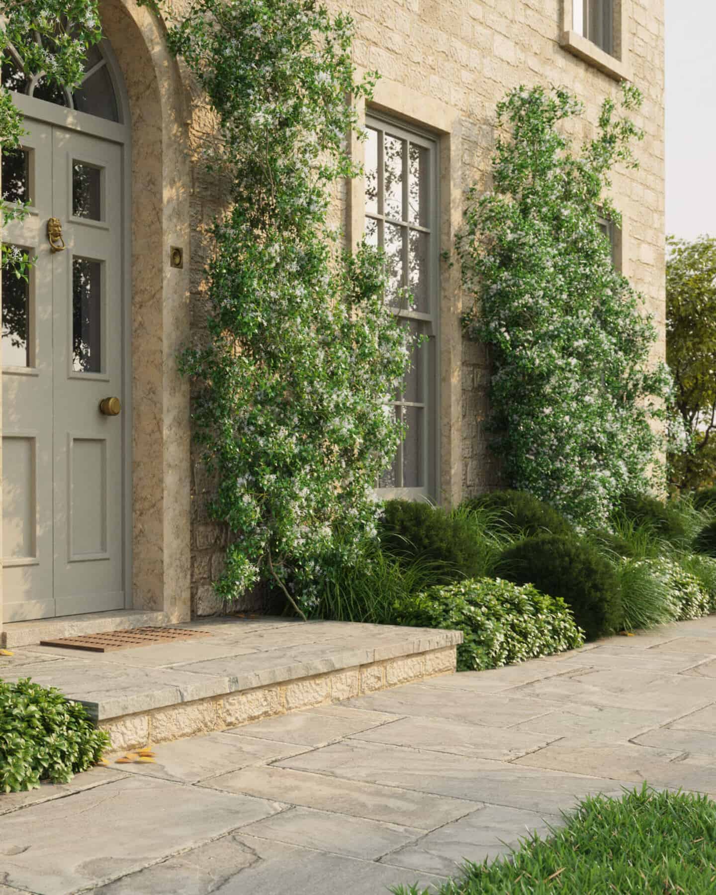 A stone home with sage green door and sash windows with lots of plants growing up the house for maximum curb appeal