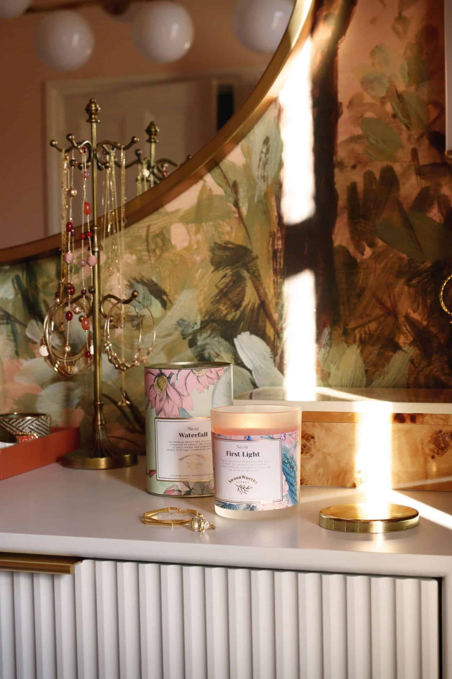 First Light, luxury eco-conscious scented candles by Swoon Worthy Scents on a chest of drawers next to a jewellry stand in the bedroom.