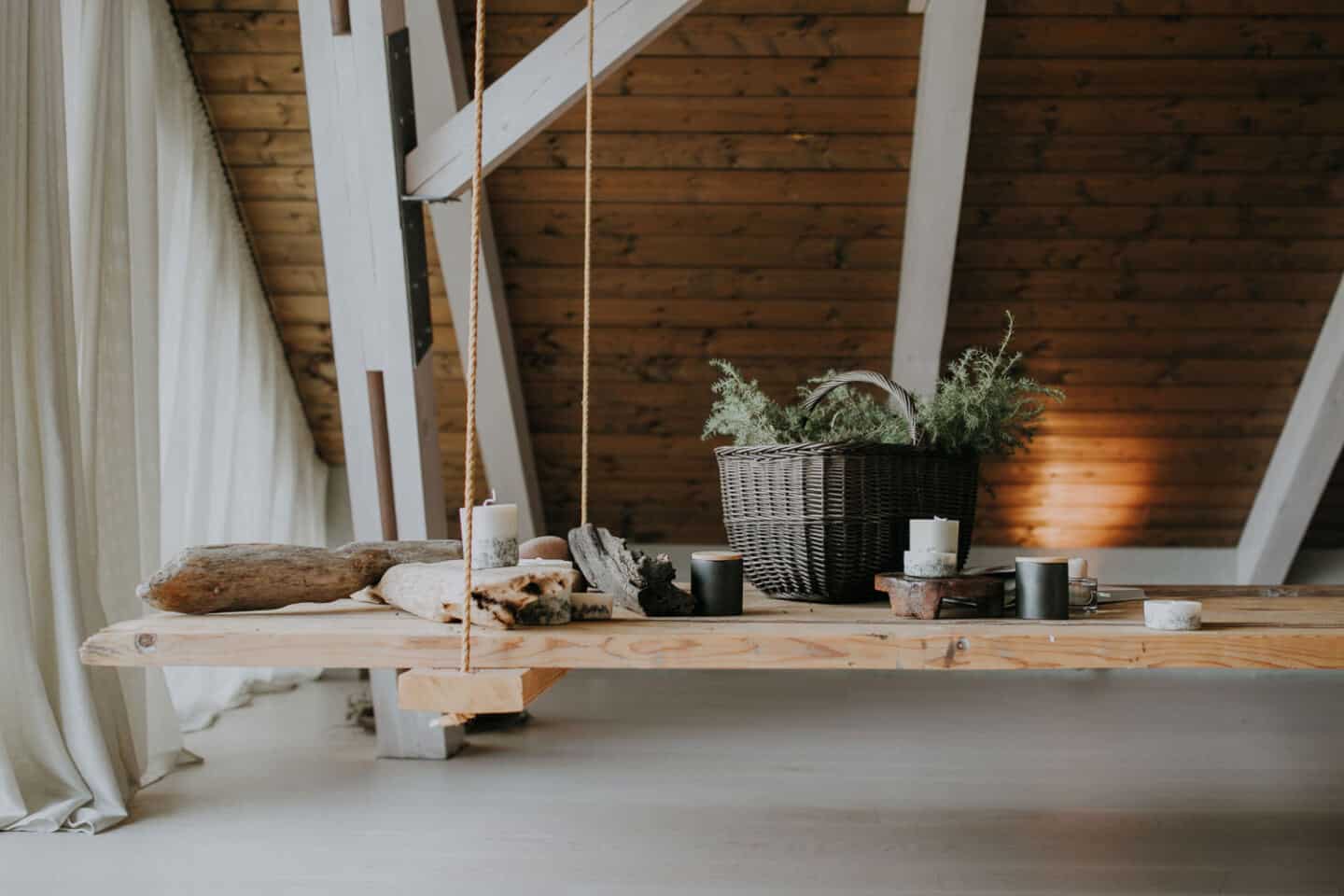 Textured Lives. Using texture in interiors to bring your home to life.  Candles and a basket of moss displayed on a wooden swing in a loft room.