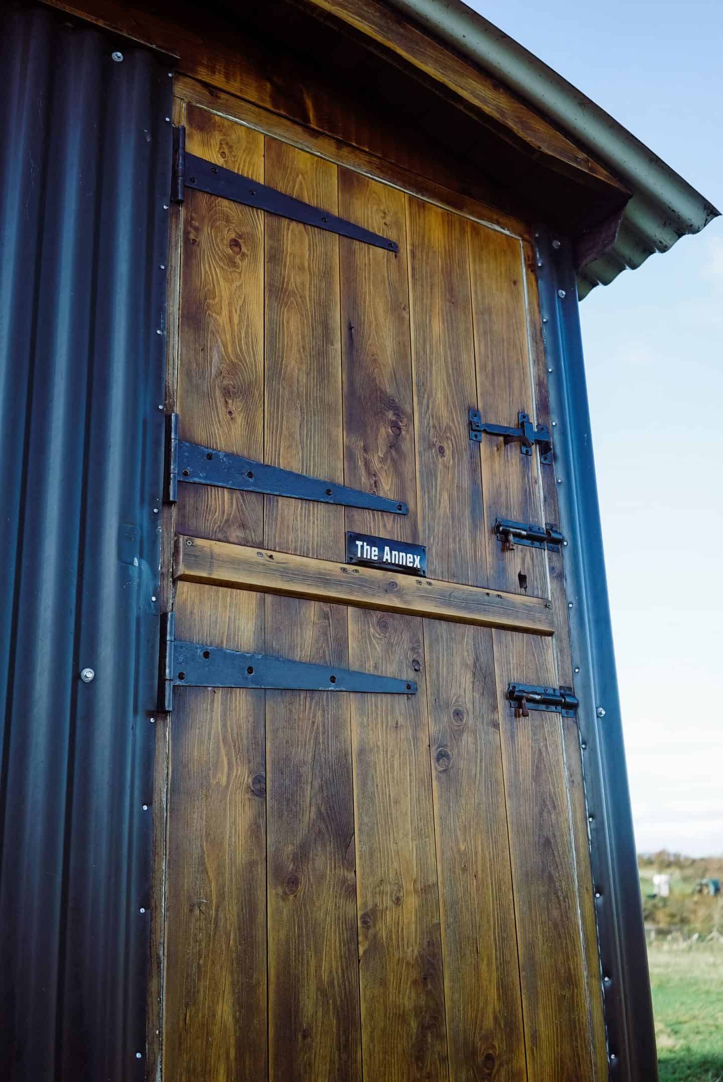 Traditional British shepherd's hut featuring an enamel sign