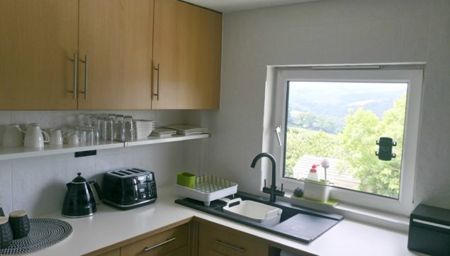 The Design Sheppard Kitchen Makeover featuring black granite sink and white laminate worktops