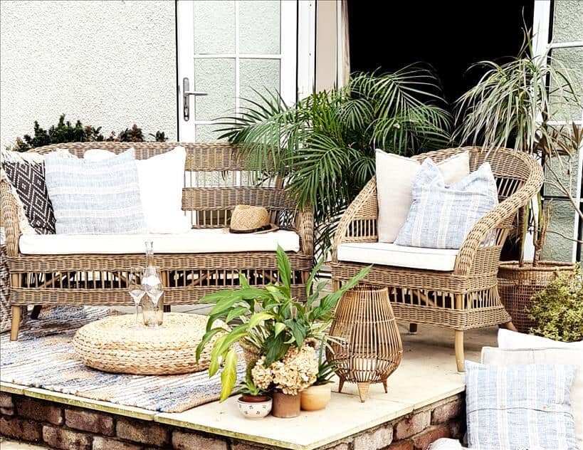 Entertain outdoors by setting up rattan furniture, rugs, cushions, pouffes and lanterns