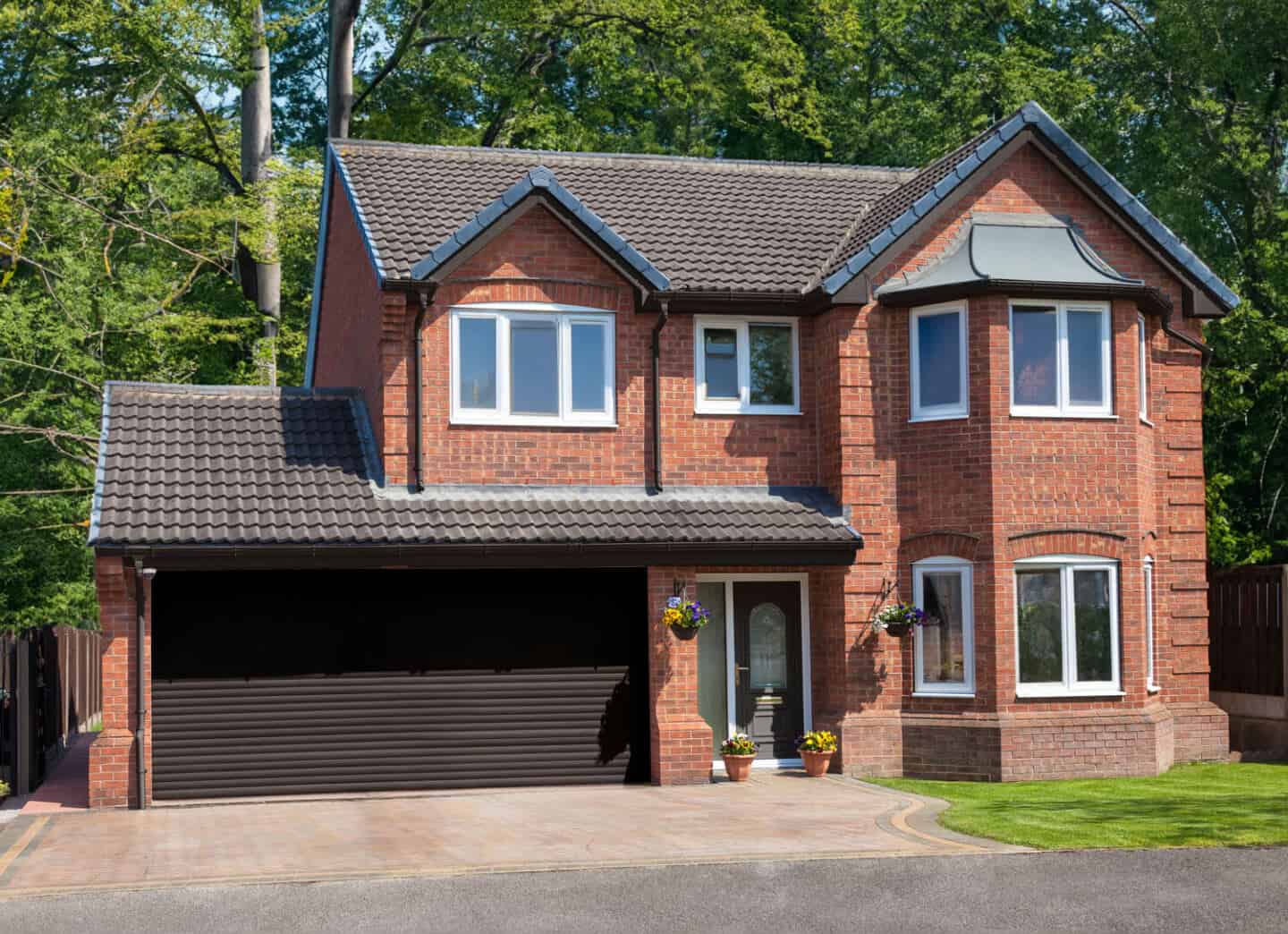 A detached red brick home with a double integral garage