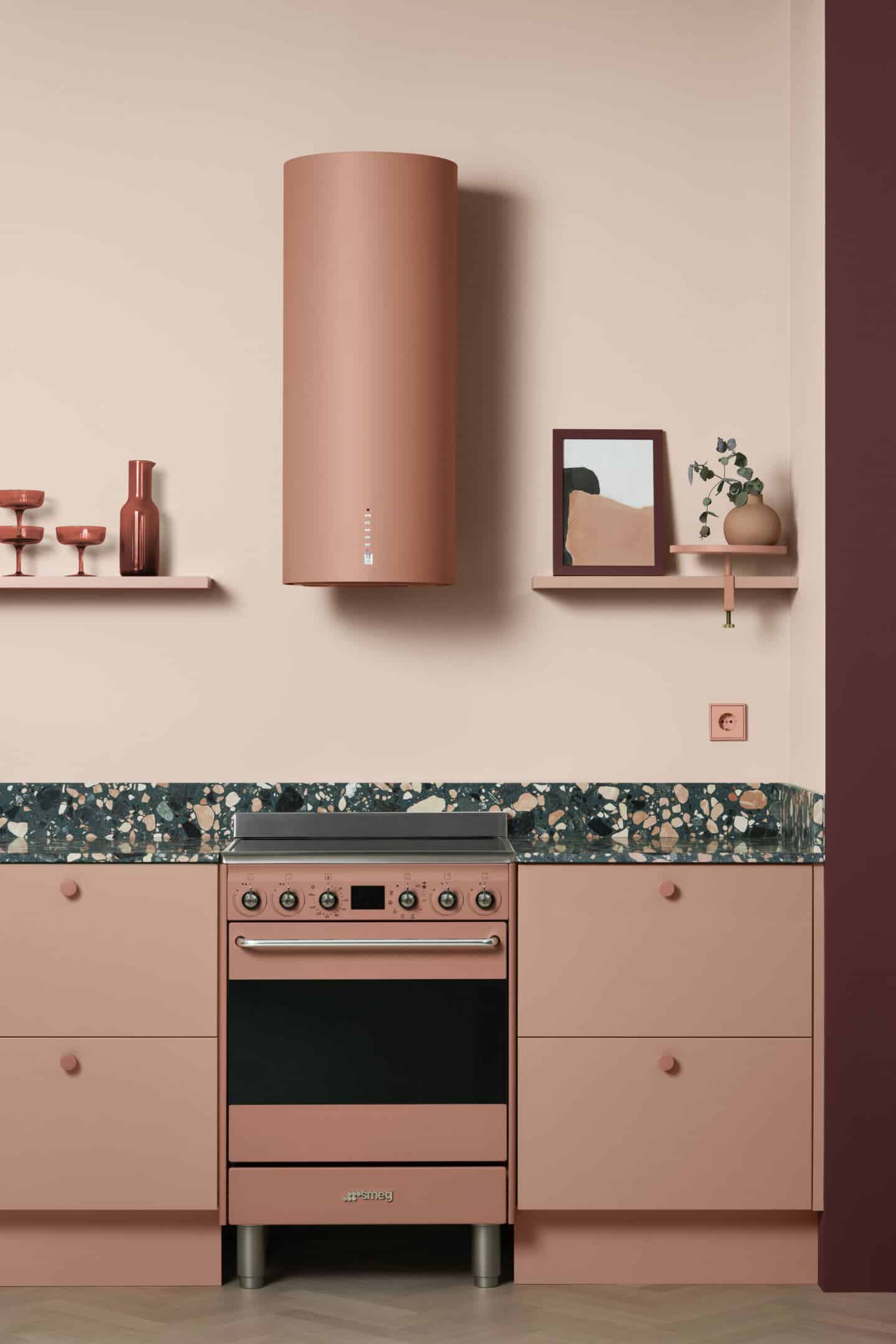 A peach kitchen from Toniton featuring a green terrazzo countertop, peach smeg oven and extractor