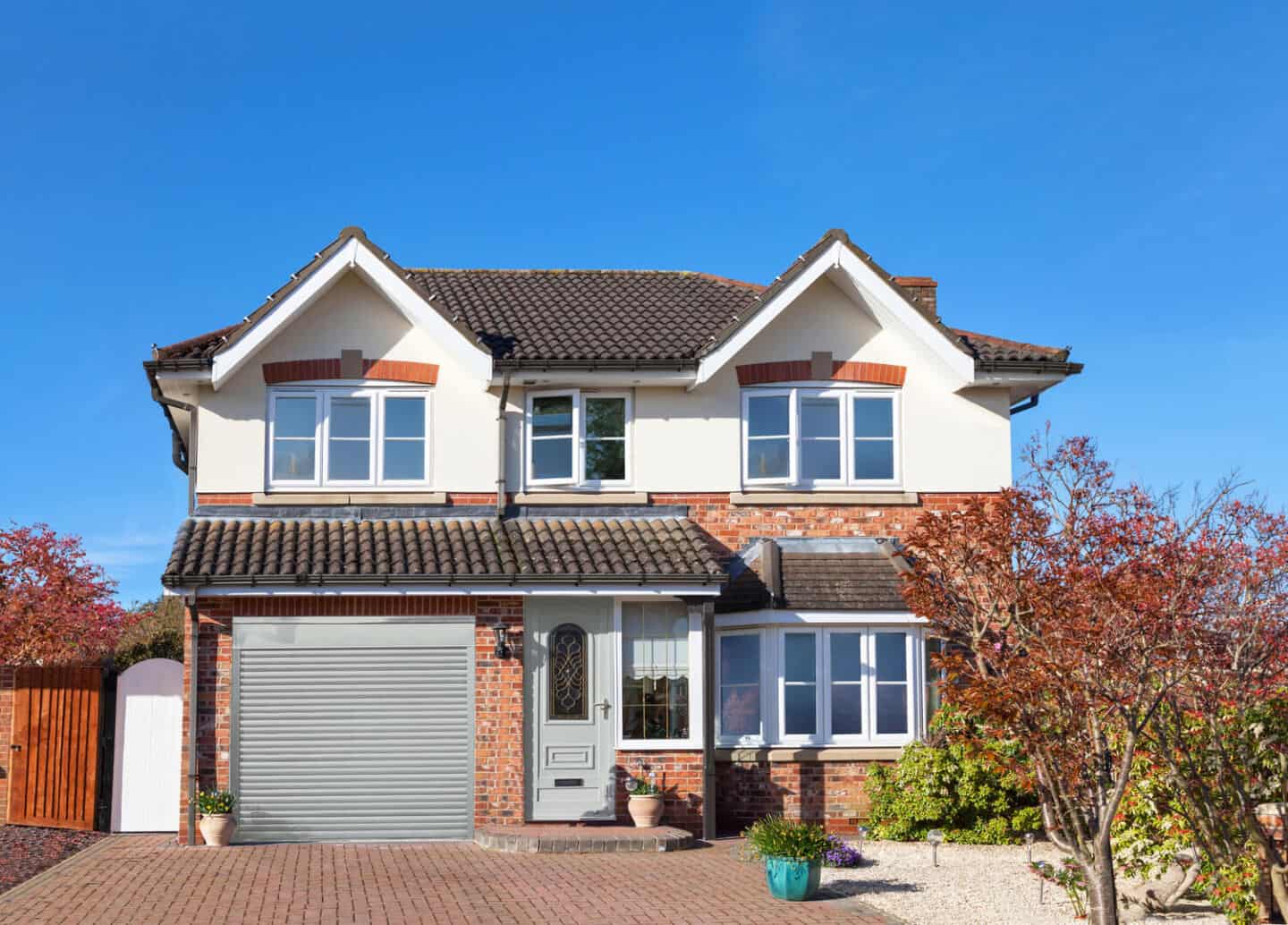 A traditional semi-detatched home with single garage with metal garage door