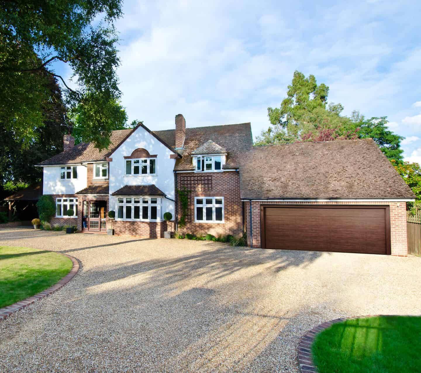 A traditional red brick home with double garage with oak wooden garage door